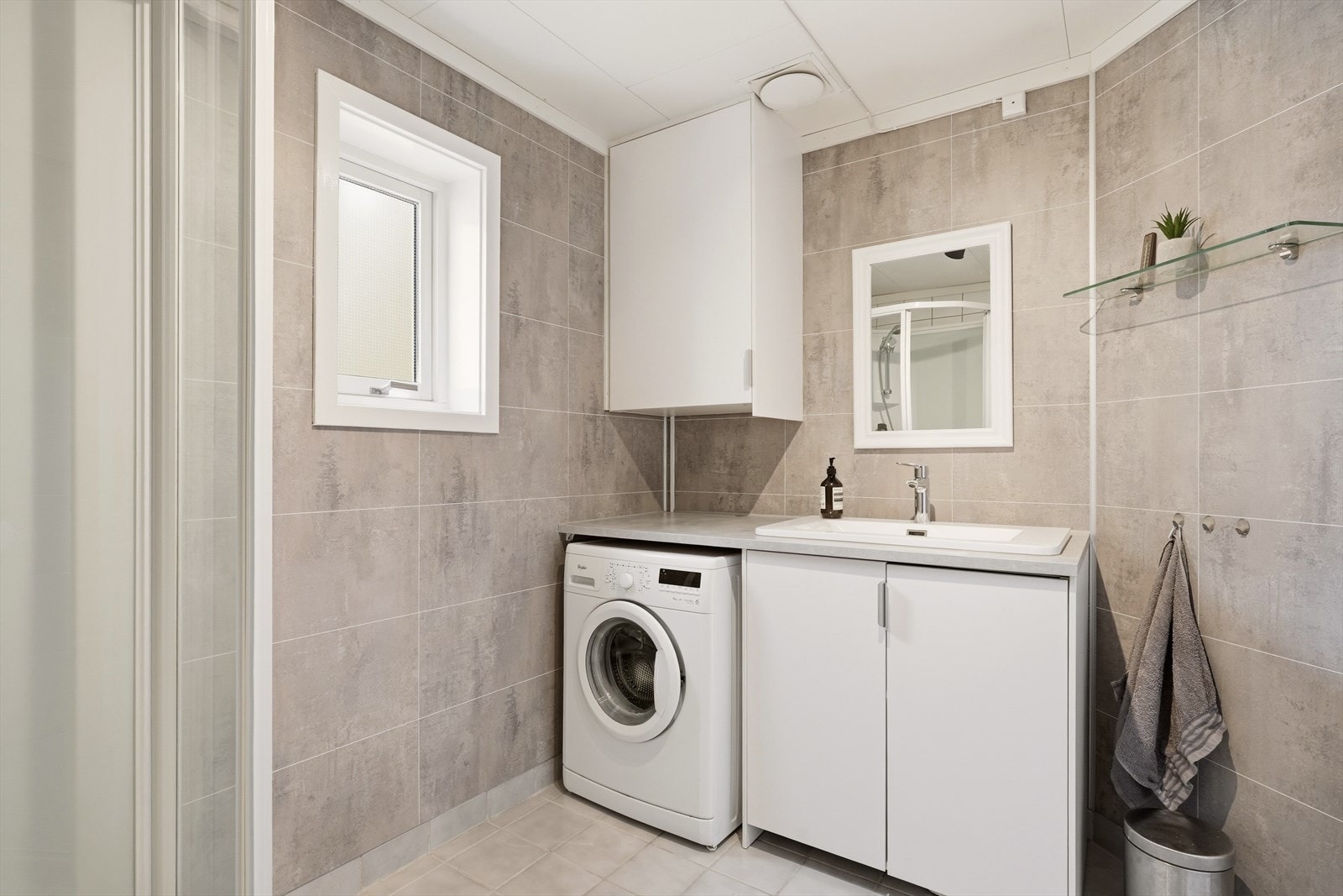 Badet er kosmetisk oppgradert i 2024 med stilrene, gråmønstrede baderomsplater på store deler av veggene. I tillegg ble det montert ny baderomsinnredning med god oppbevaringsplass, nytt dusjkabinett og nytt toalett. Galleribilde