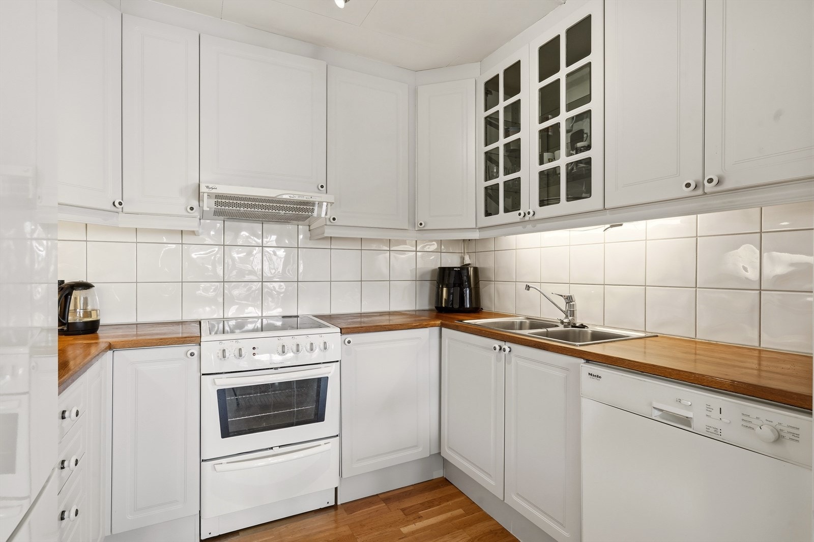 Tidløst kjøkken med lyse profilerte fronter og heltre eik benkeplate. Galleribilde