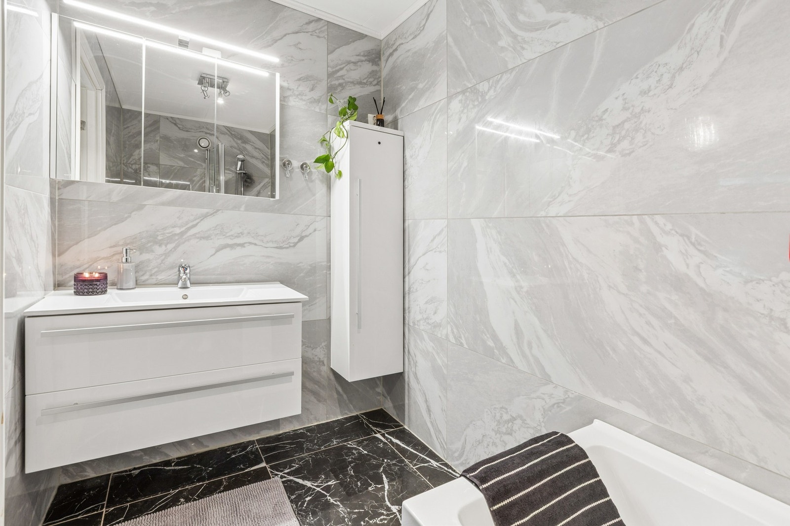 Flislagt gulv med elektrisk gulvvarme og flislagte vegger. Himling med takessplater. Vegghengt servantskap med heldekkende servant og ett-greps armatur. Galleribilde