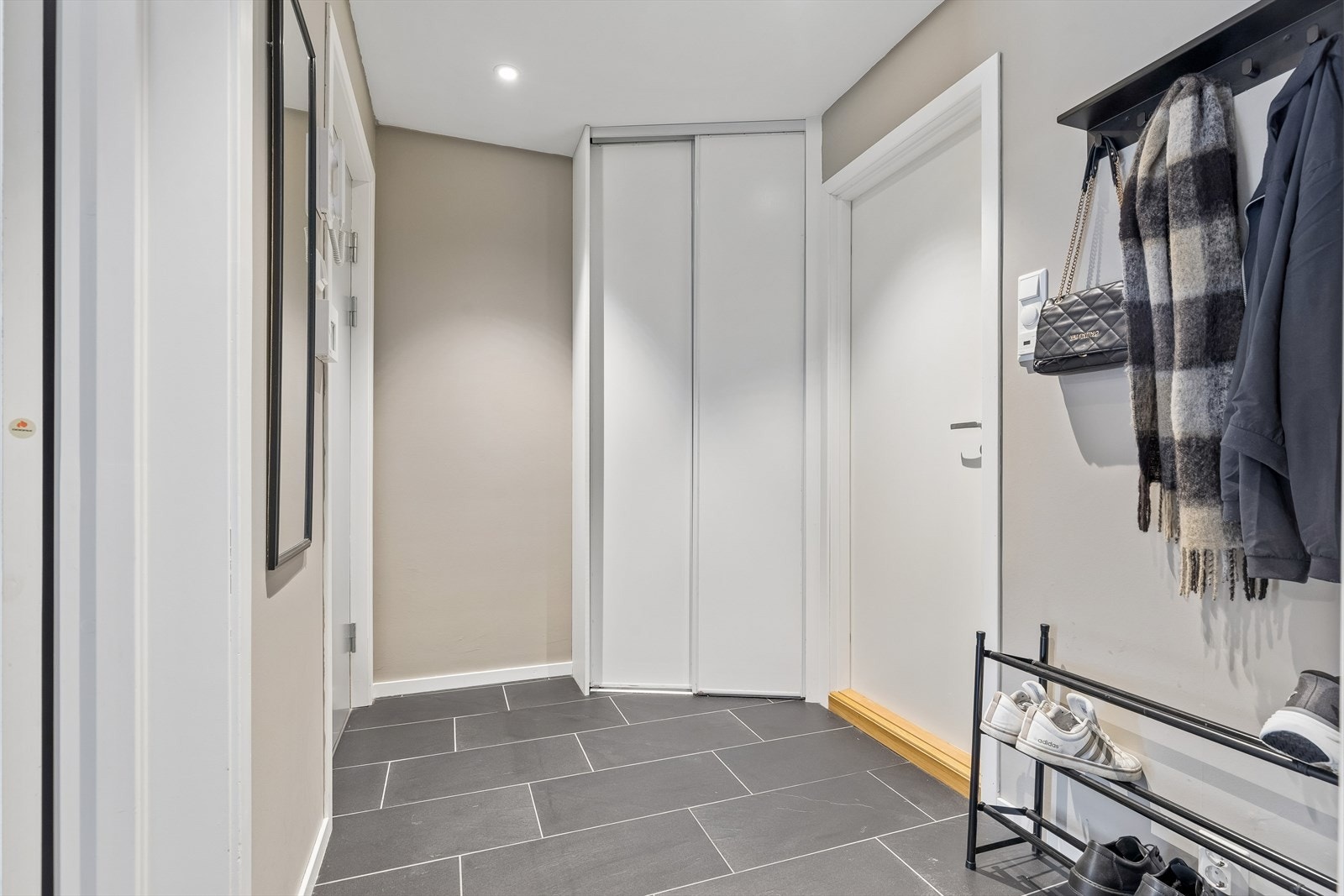 Innbydende entré med plass til yttertøy og en praktisk skyvedørsgarderobe for oppbevaring. Galleribilde