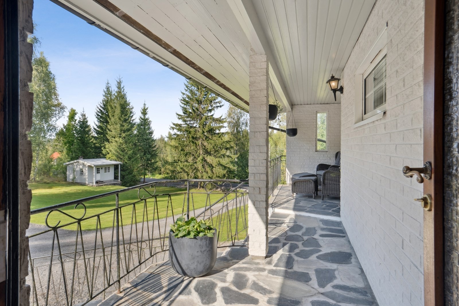 Overbygd inngangsparti - Boligen er kledd med både stående bordkledning og teglstein. Galleribilde