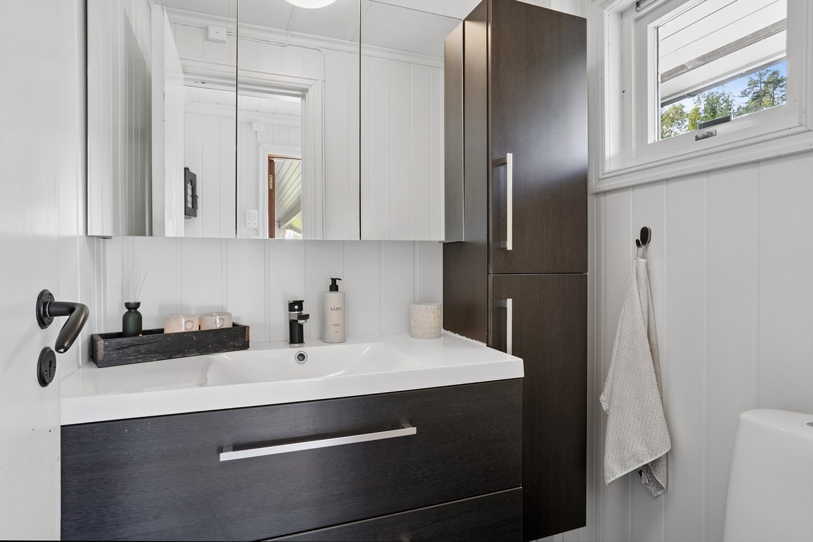 Lite wc-rom med gulvstående toalett og heldekkende servant i innredning. Galleribilde