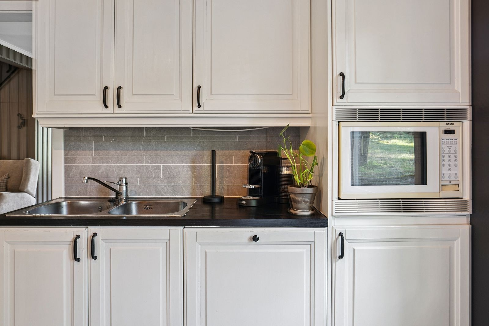 Profilert kjøkkeninnredning, laminat benkeplate og plater med flismønster over kjøkkenbenk. Galleribilde