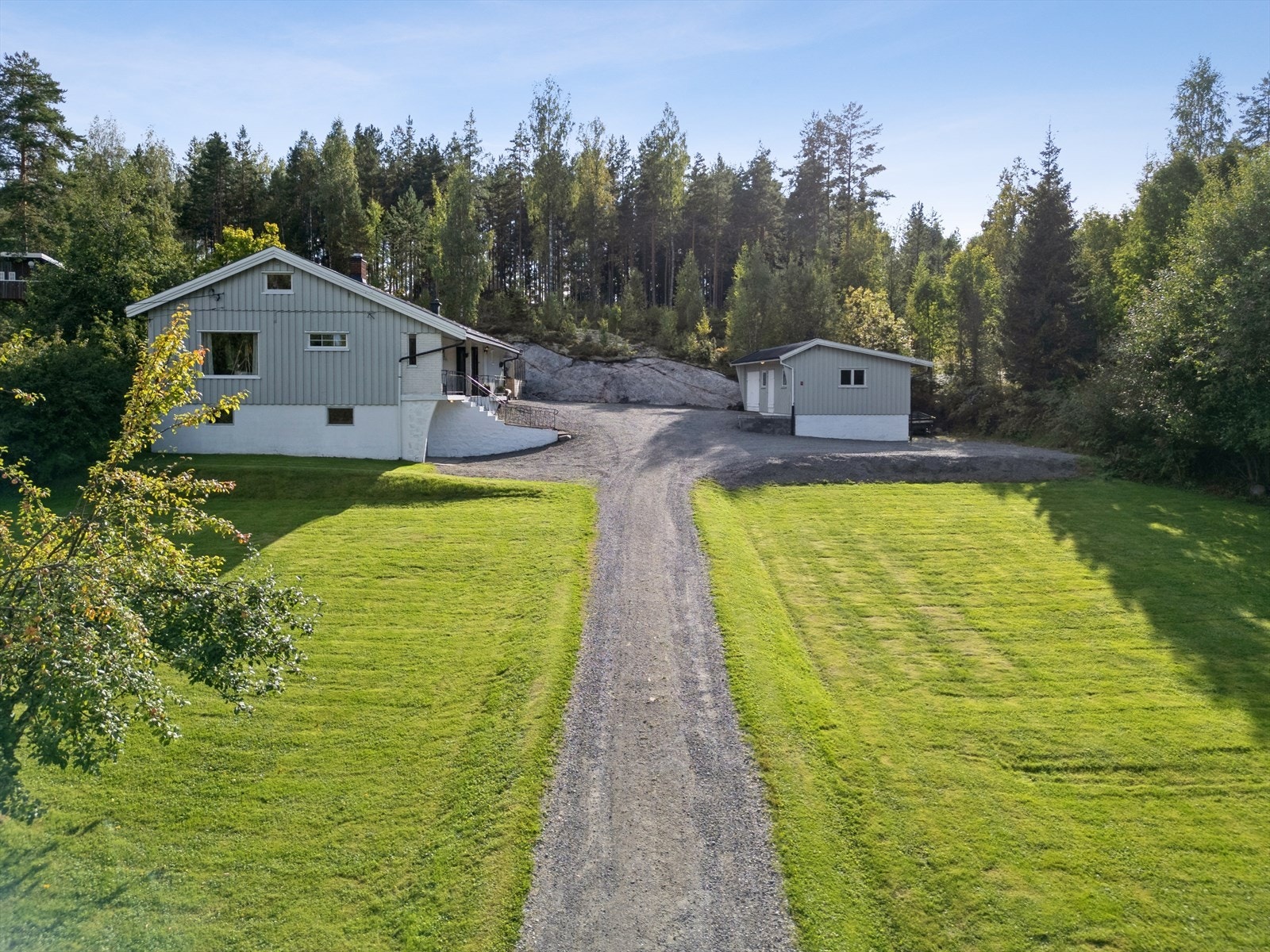 Tomten er pent opparbeidet og det er gruset innkjørsel og gårdsplass til eiendommen. Galleribilde
