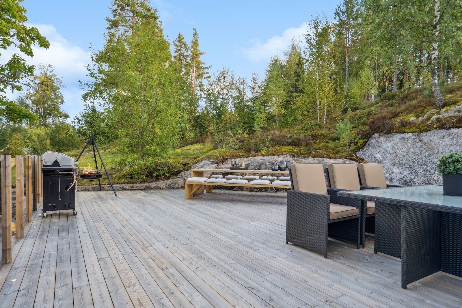 Stor terrasse med god plass til utemøbler, grill og bålpanne og med grense til naturtomt. Galleribilde