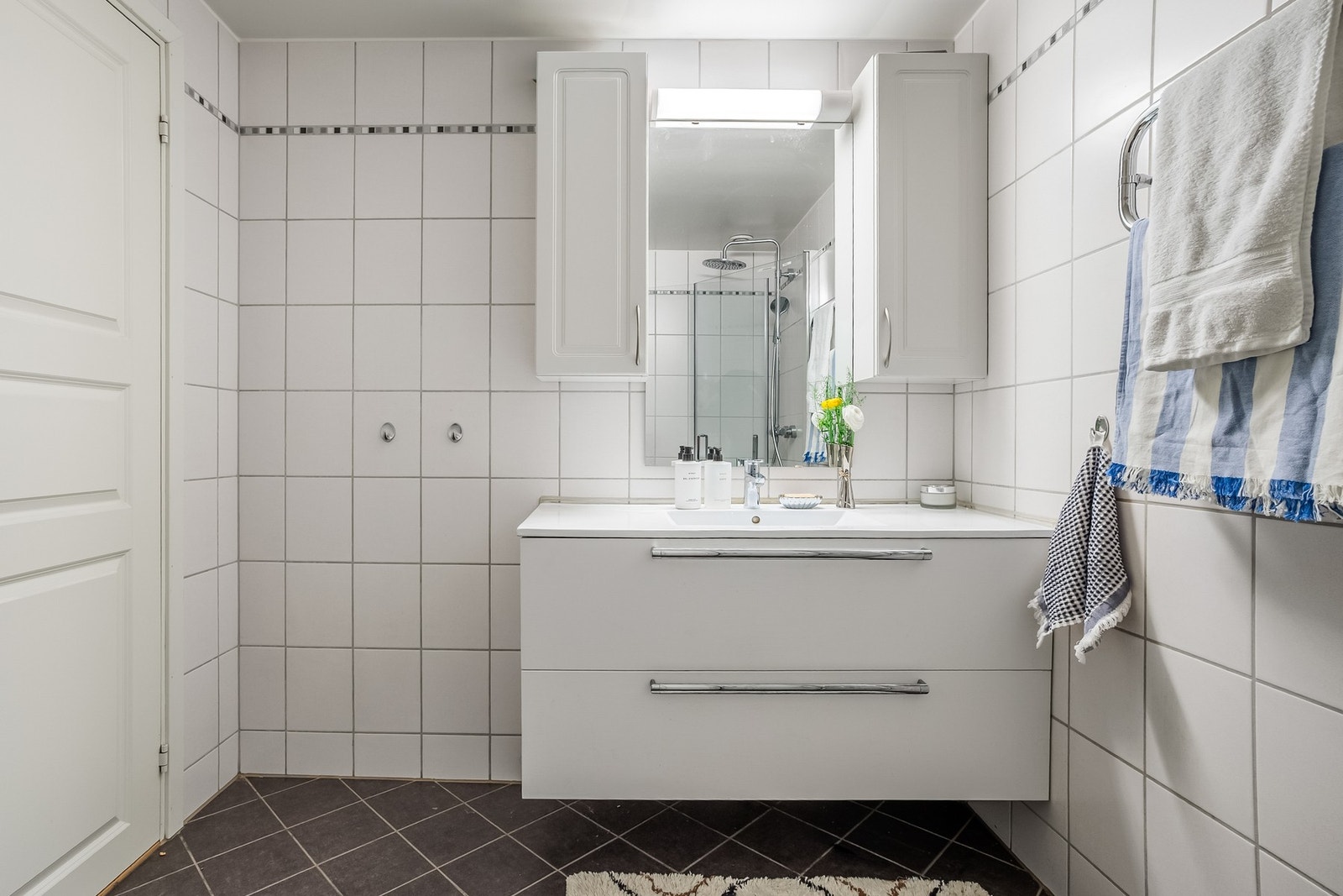 Badet er utstyrt med servantinnredning, gulvstående toalett og dusj på gulv. Det er varmekabler i gulvet og mekanisk avtrekk. Galleribilde