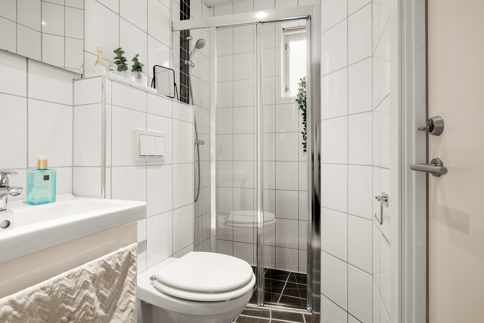 Badet i leiligheten er helfliset, med fine baderomsmøbler og lyse overflater. Galleribilde