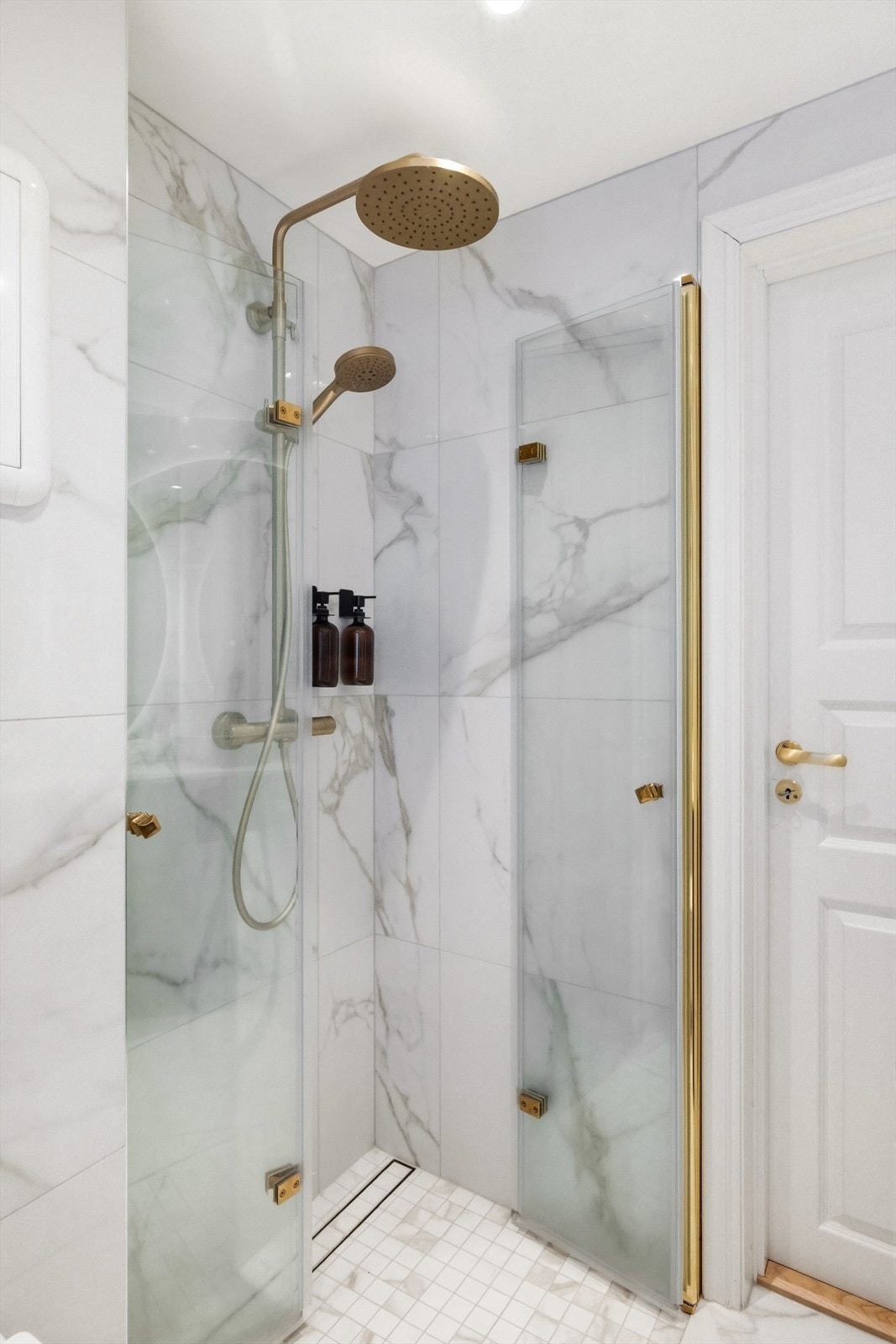 Dusjhjørne med foldedører, sluk i dusjsone, regnfallsdusj og termostatstyrt blandebatteri. Det er også varmekabler i gulv. Galleribilde