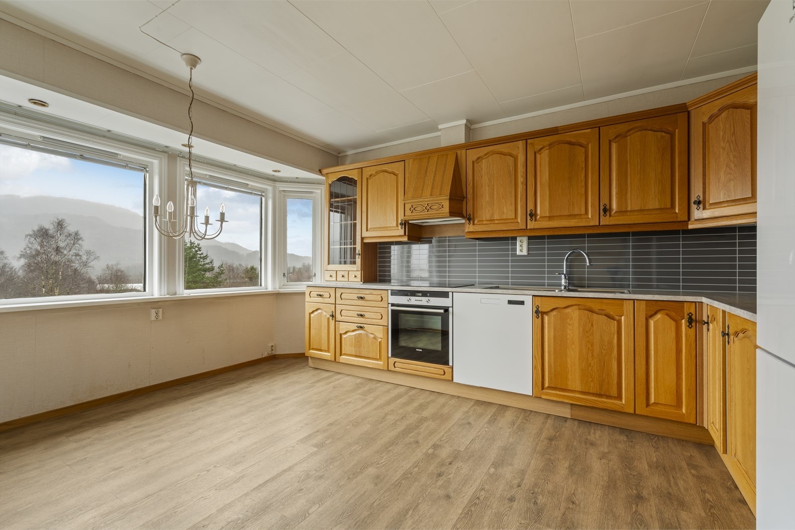 Kjøkken med god skap, skuffe- og benkeplass.
Benkeplate av nyere dato. Hvitevarer følger med i handelen. Galleribilde