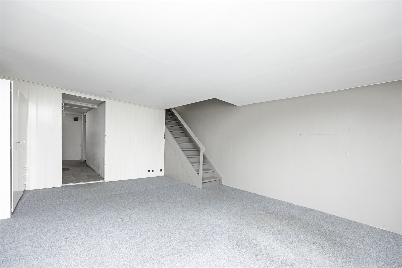 Via trapp fra gangen kommer man ned i kjelleretasjen hvor det er kjellerstue, vaskekjeller og bodplass. Kjellerstua har malte veggoverflater og teppe på gulvet. Galleribilde