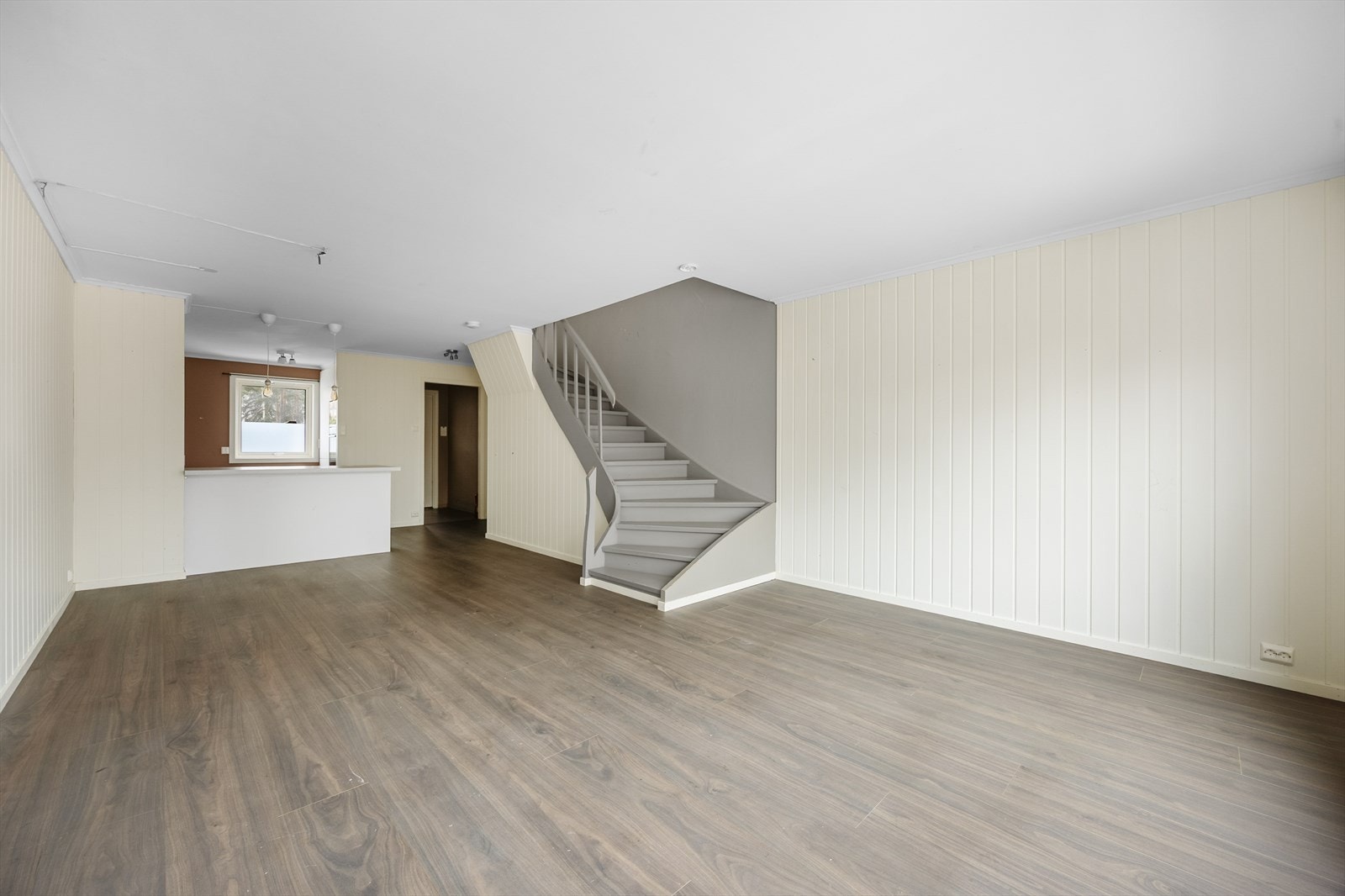 Leiligheten har en fin, åpen løsning mellom stua og kjøkkenet, med en praktisk kjøkkenhalvøy som et naturlig skille mellom rommene. Galleribilde