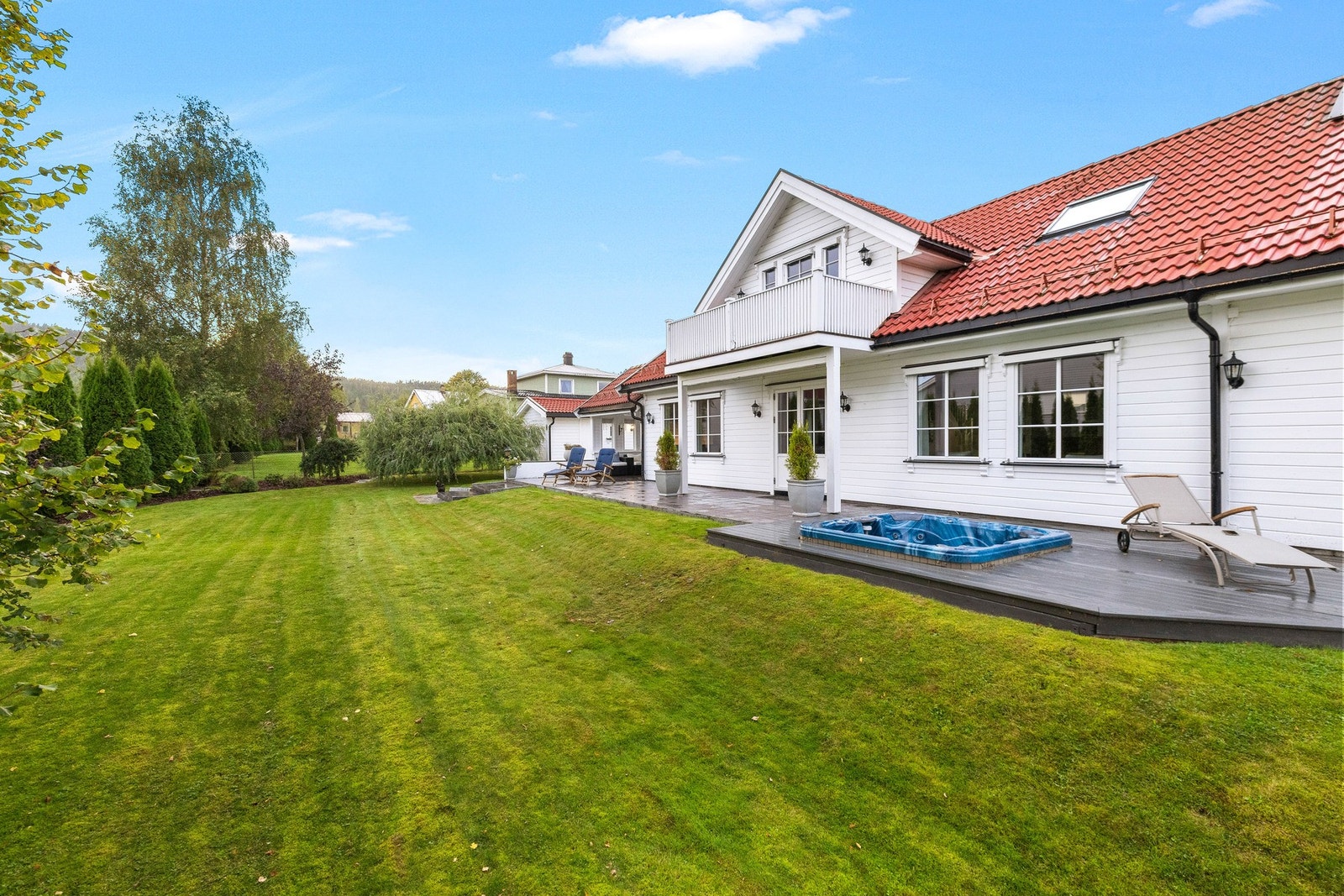 Tomten er svært pent opparbeidet med grønne plenarealer, prydbusker, trær og variert beplantning som skaper en lun og innbydende ramme rundt boligen. Galleribilde
