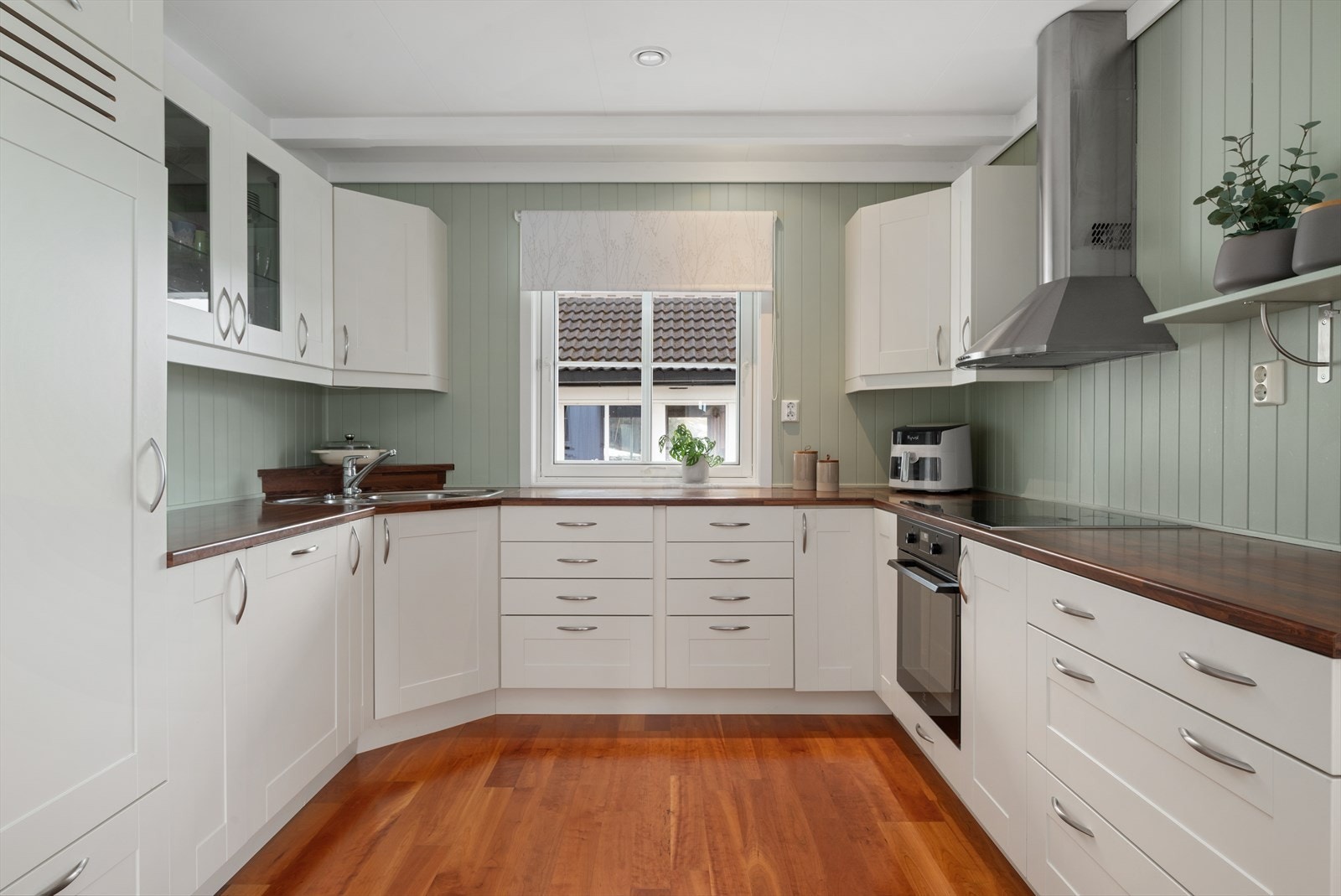 Romslig kjøkkeninnredning med integrerte hvitevarer. Galleribilde