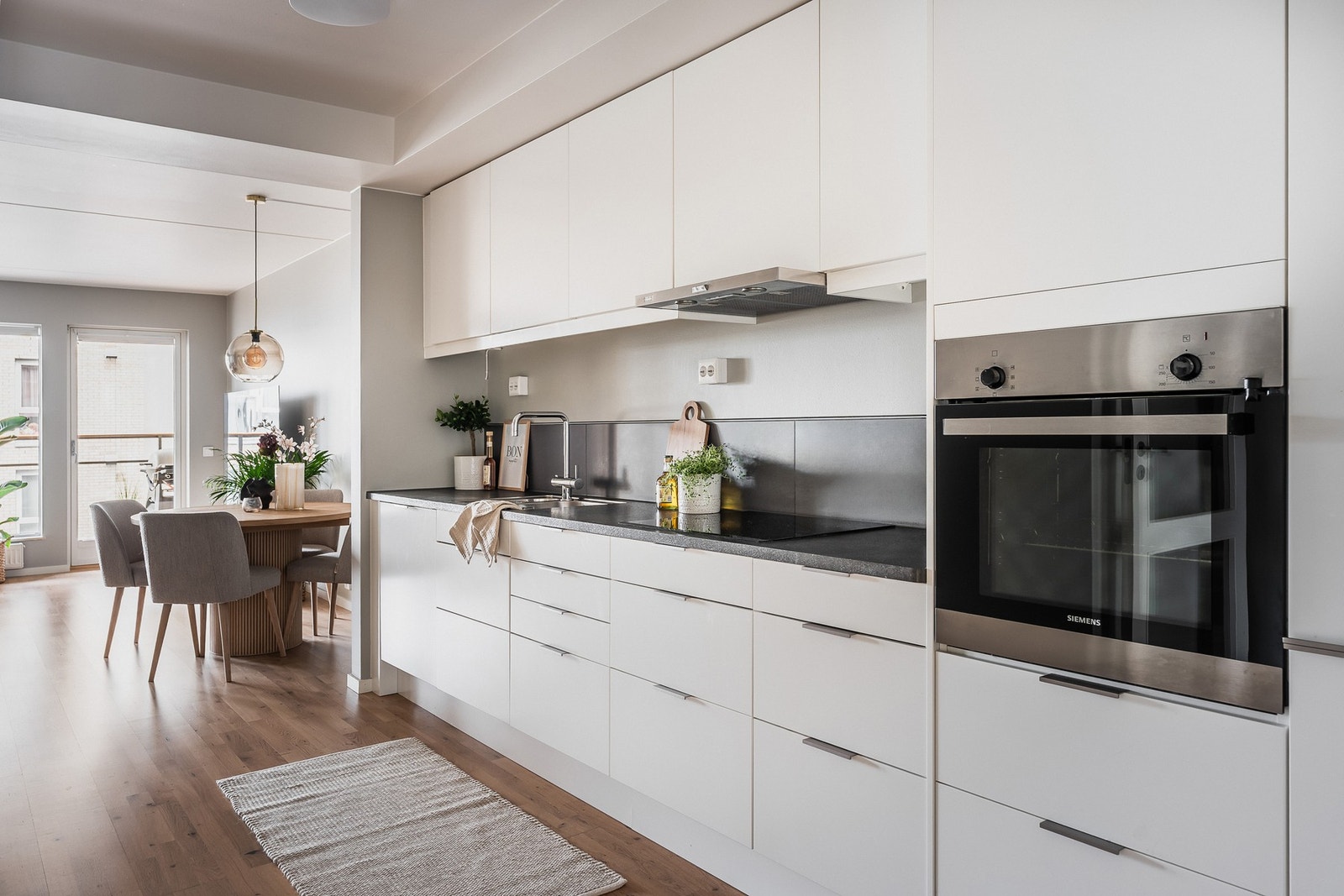 Kjøkkenet ligger i åpen løsning til stuen. Innredning (2019) med slette fronter og integrerte hvitevarer bestående av induksjonstopp, stekeovn, oppvaskmaskin samt integrert kjøl/frys. Galleribilde