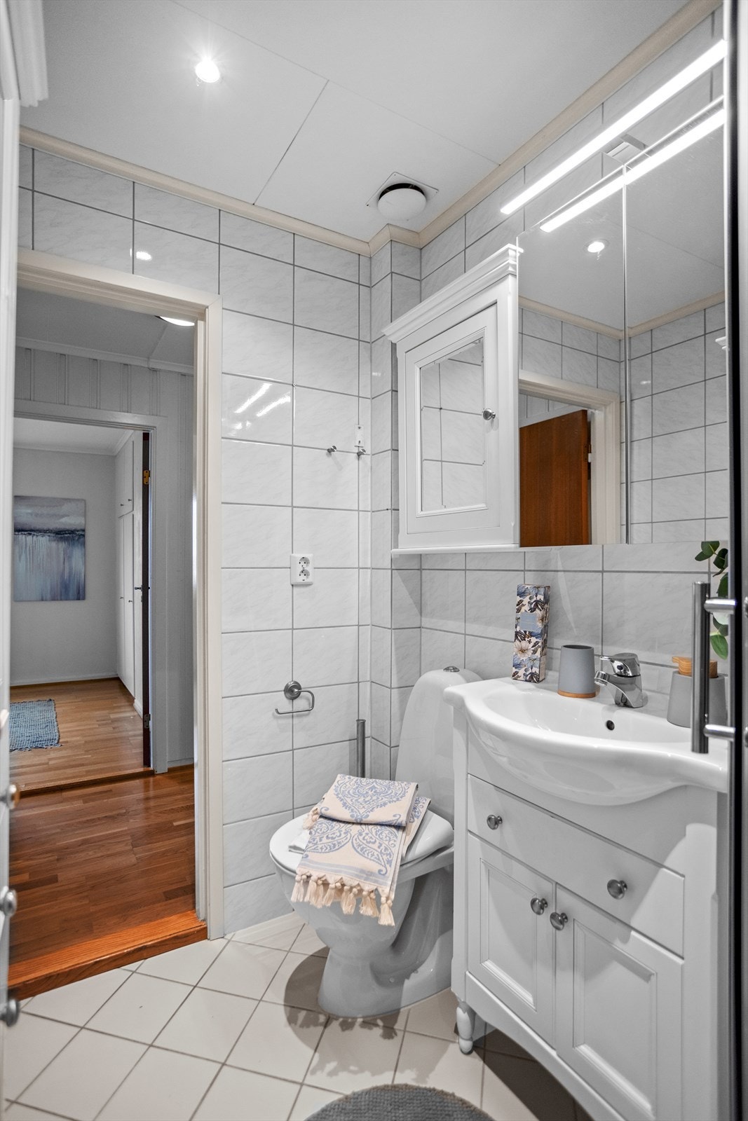 Baderommet byr på mange fine detaljer, lyse farger, tradisjonelt flisvalg og innredninger med god oppbevaringsplass. I dusjløsningen, innerst i rommet, finner man dusjkabinett. Galleribilde