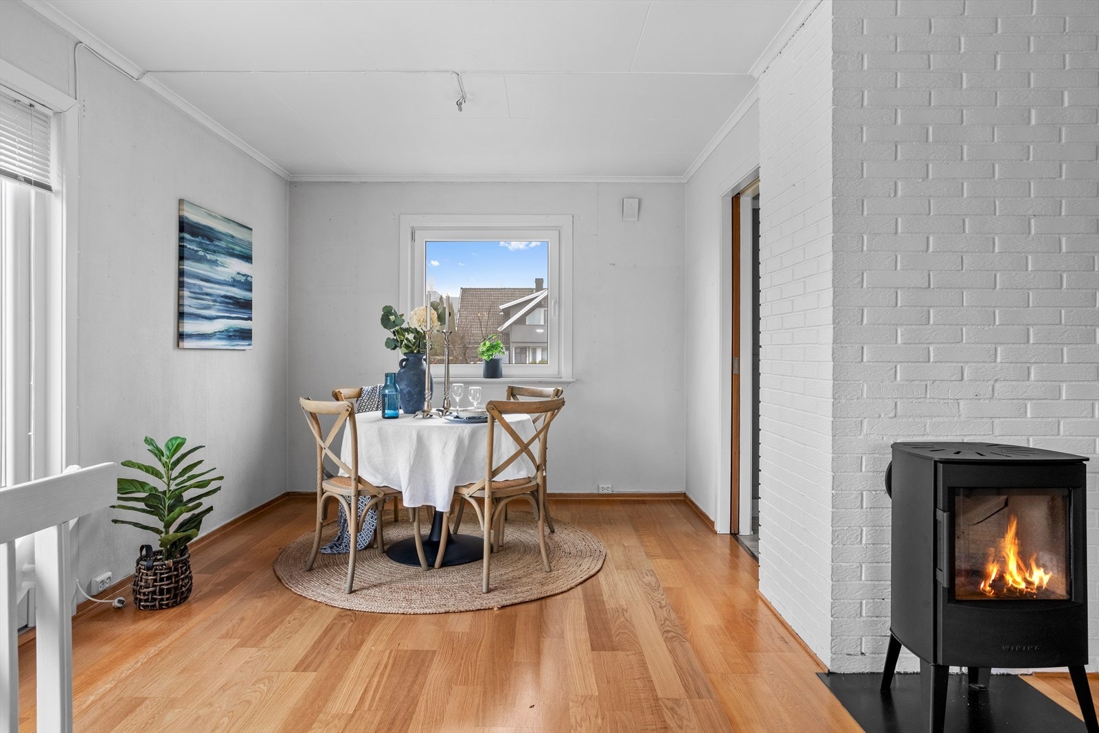 Sentralt i rommet sørger en lite plasskrevende peisovn for peiskos og ekstra god varme på mørke vinterkvelder. Galleribilde