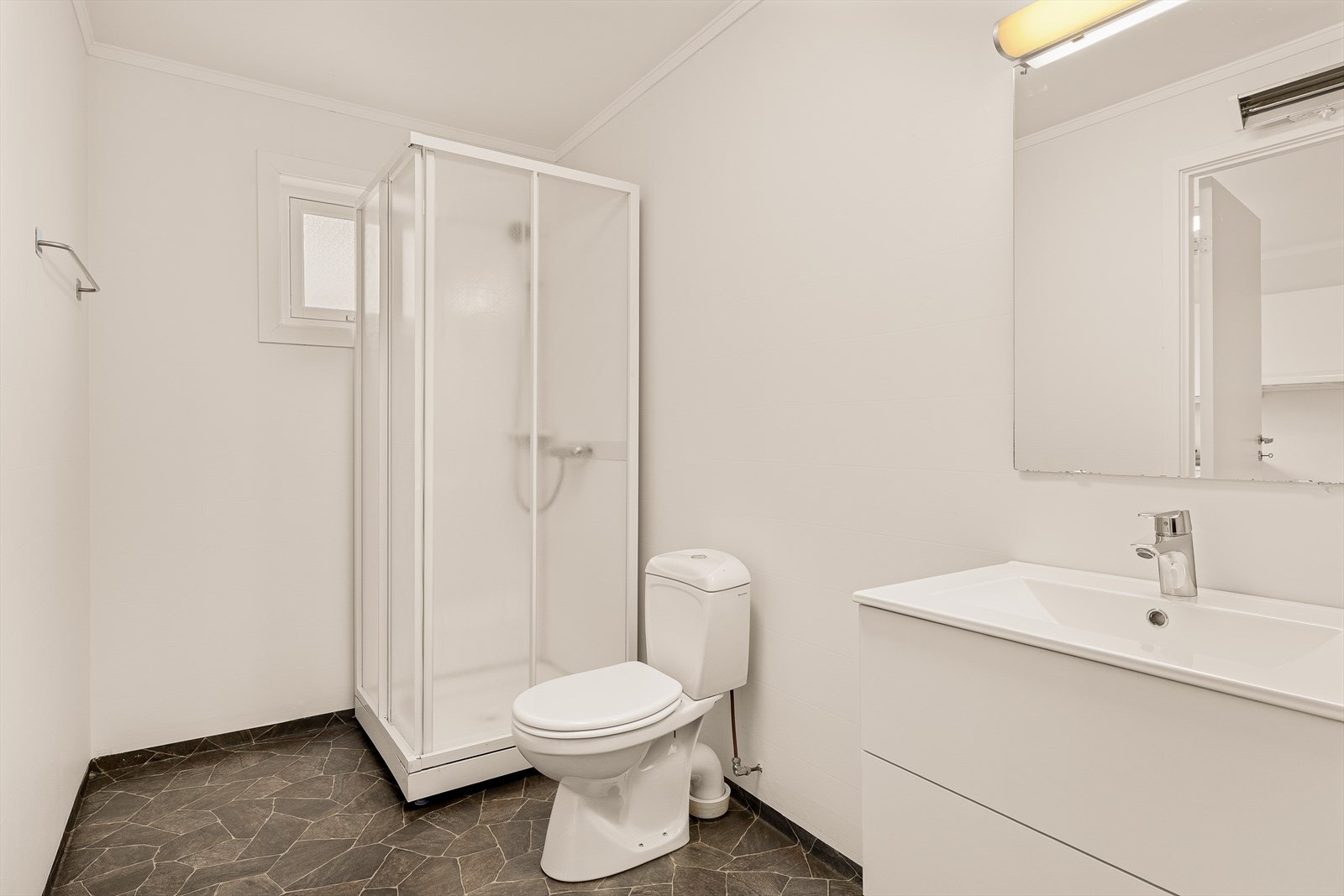 Rommet er utstyrt med dusjkabinett og toalett. Varmtvannsberederen på 120 liter er plassert her. Galleribilde