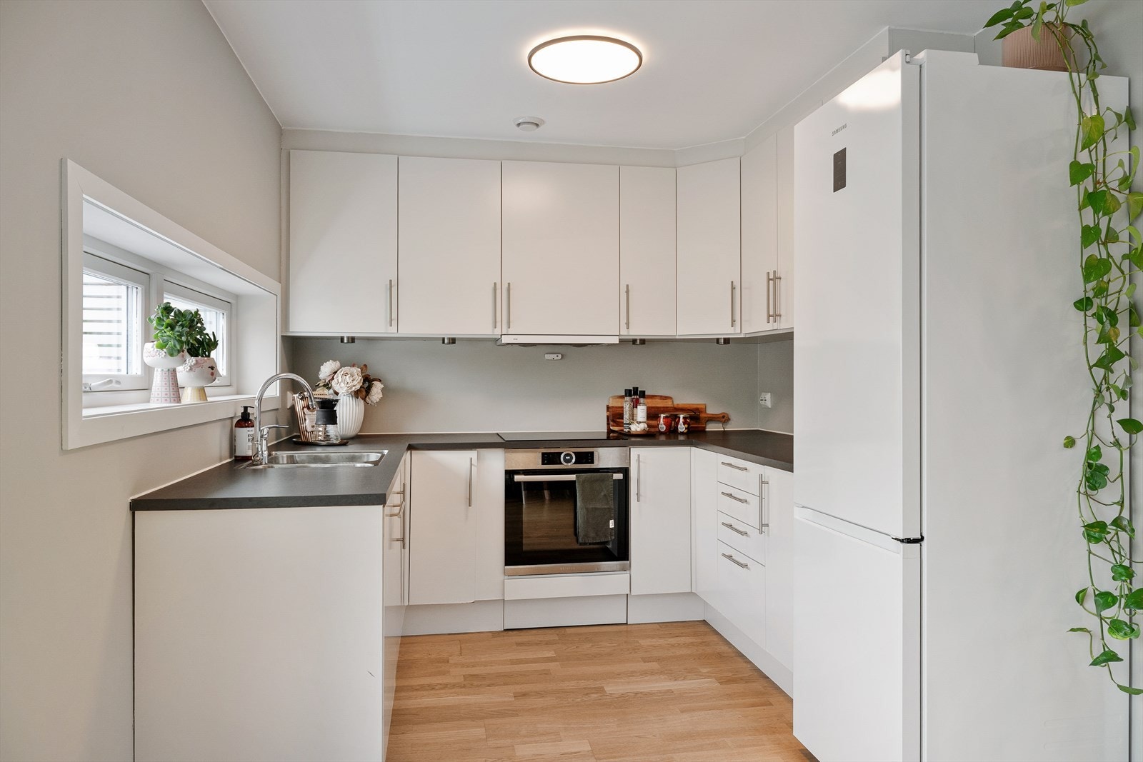 Kjøkkenet er tidløst utformet med laminatbenkeplate og har hvit innredning og fremstår både funksjonelt og stilrent. Galleribilde