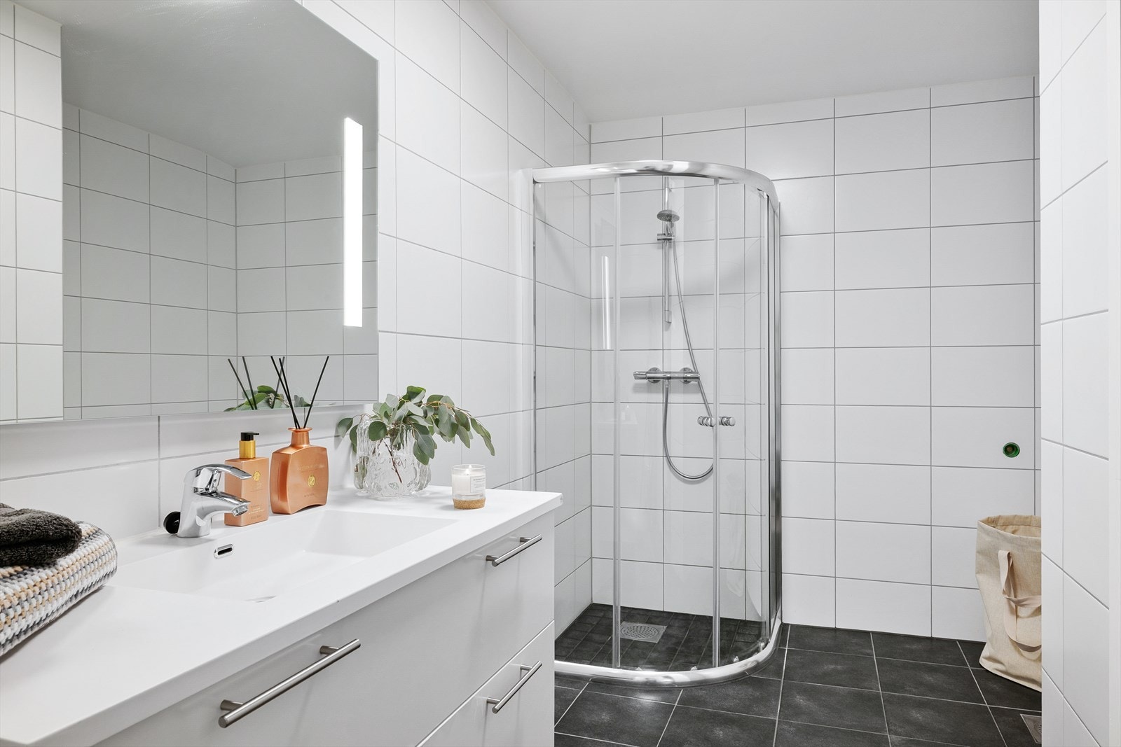 Baderommet i tredje etasje er delikat og helfliset, med varme i gulvet. Rommet er innredet med dusjhjørne, servant med underskuffer, speil og vegghengt toalett. Galleribilde