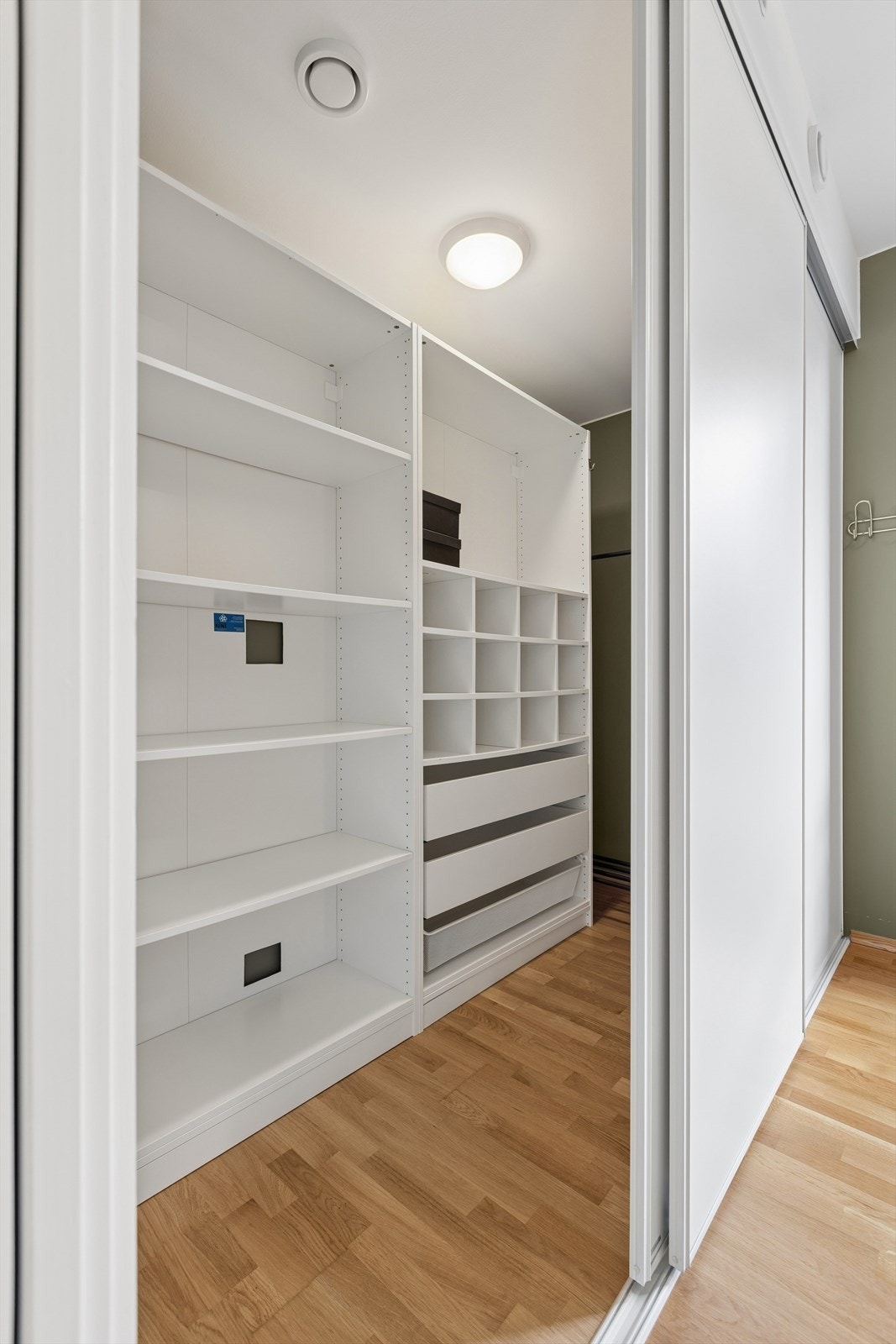 Bak skyvedører har man tilkomst til leilighetens innvendige bod som i dag benyttes som "walk-in" garderobe og gir god lagringsplass. Galleribilde