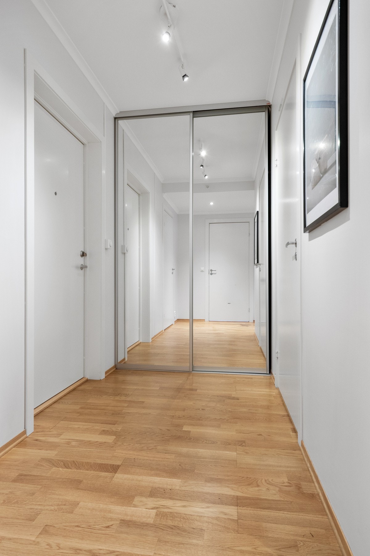 Entréen fremstår lys og ryddig med parkett på gulv og malte flater som gir et moderne førsteinntrykk. Galleribilde
