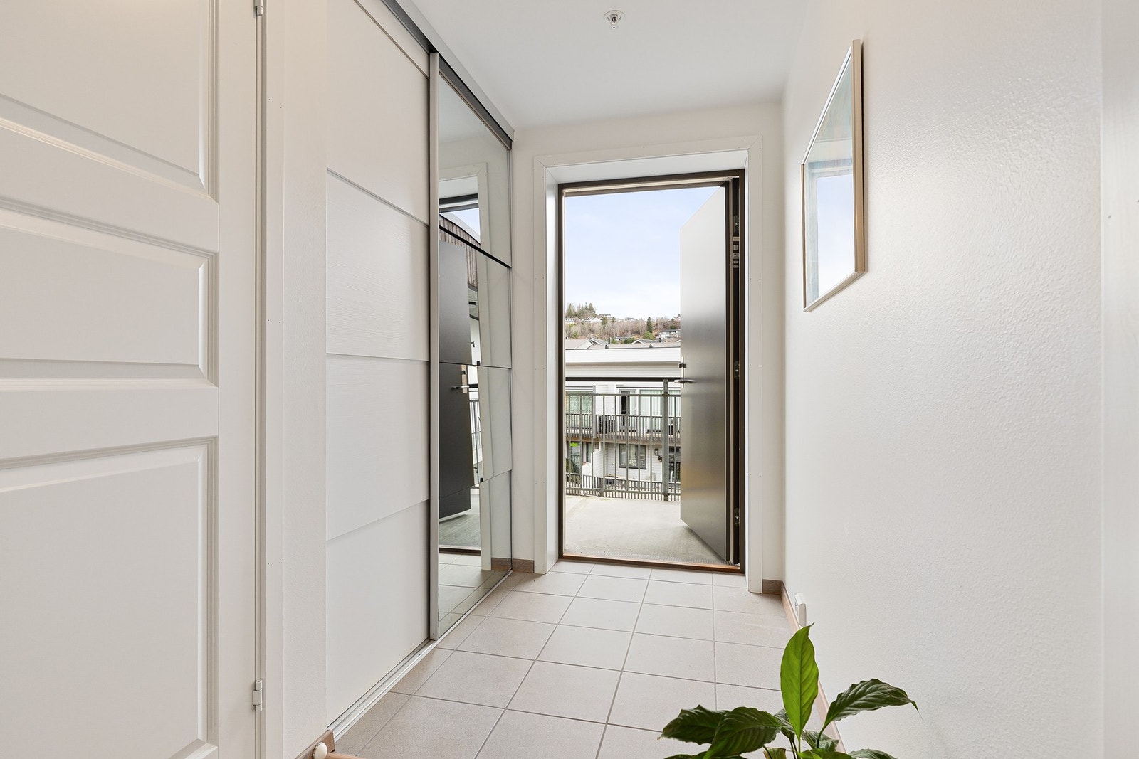 Velkommen inn. Flislagt entré med praktisk og romslig skyvedørsgarderobe med speil. Galleribilde