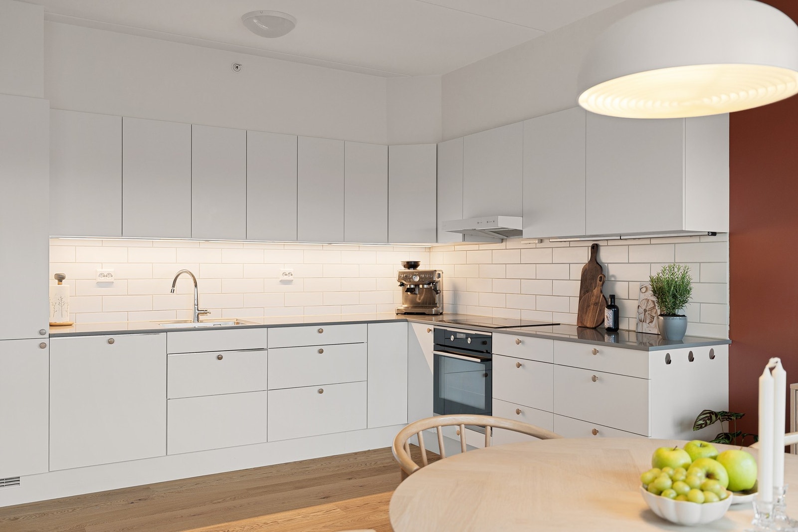 Lyst, tidløst og pent brukt kjøkken med integrerte hvitevarer og gode arbeidsflater. Galleribilde