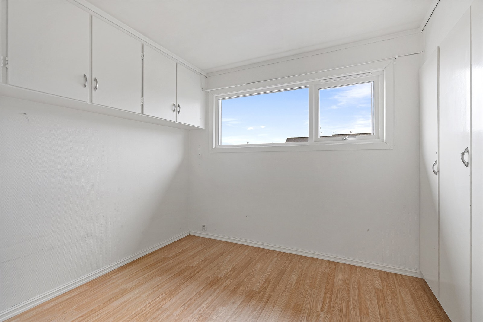 Soverommet er praktisk innredet med plassbygde garderobeskap og overskap for effektiv oppbevaring. Galleribilde