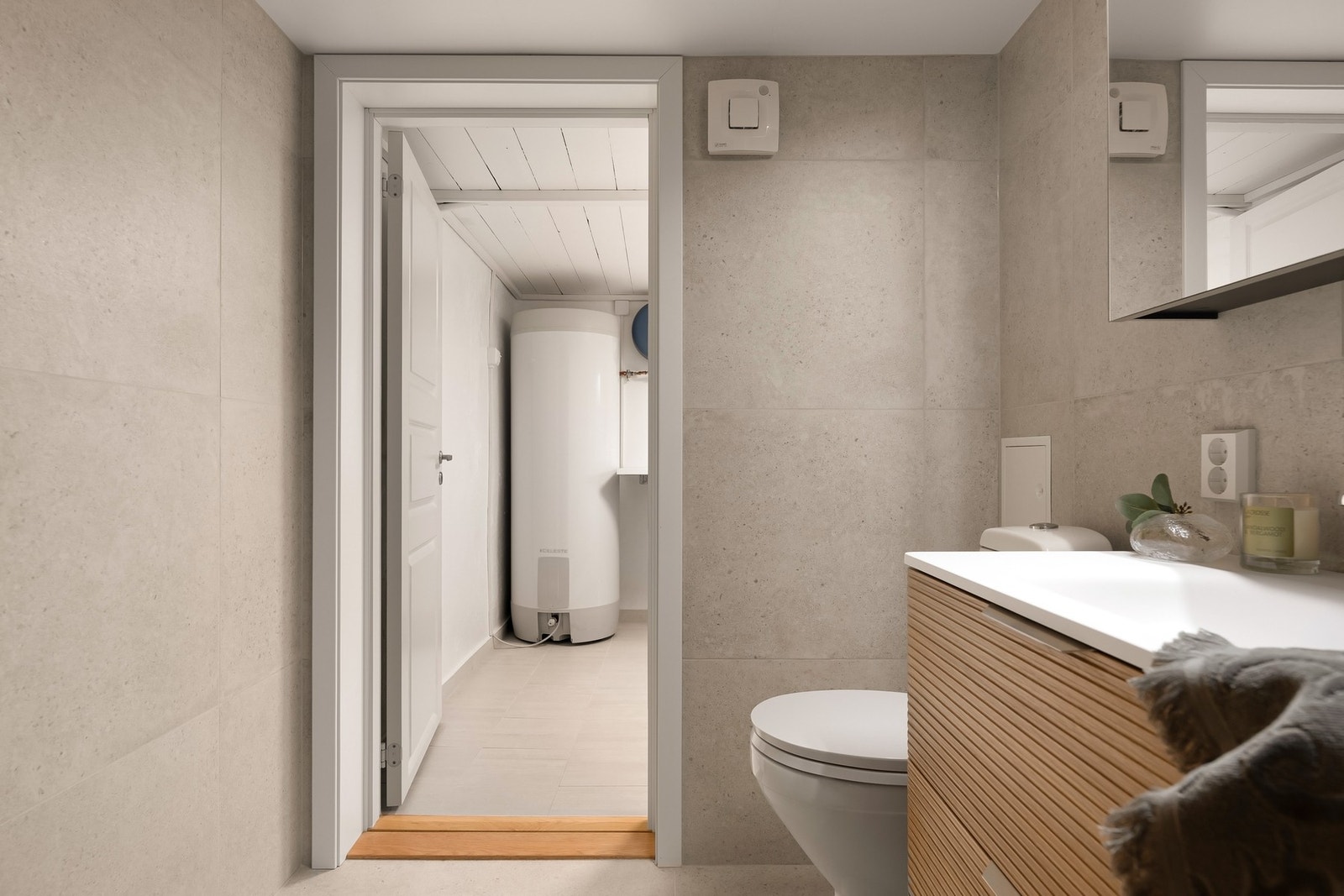 Badet er utstyrt med gulvstående wc, baderomsinnredning og dusjhjørne Galleribilde