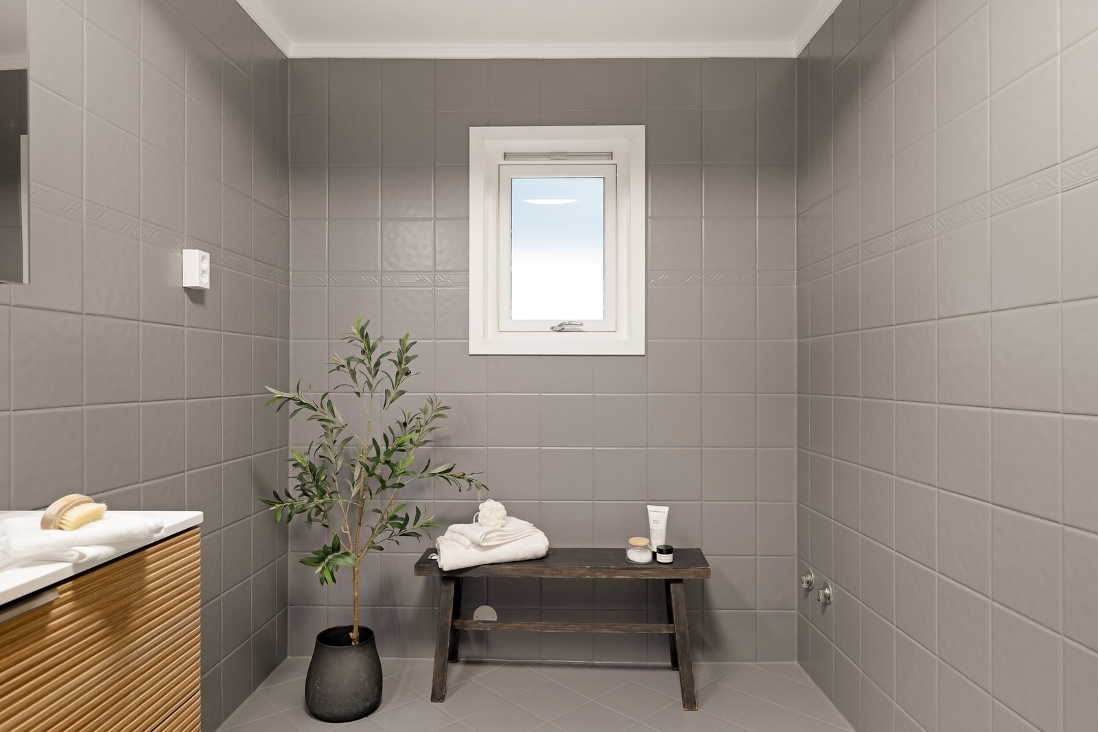Badet er utstyrt med veggmontert wc, baderomsinnredning, dusjkabinett og opplegg for badekar Galleribilde