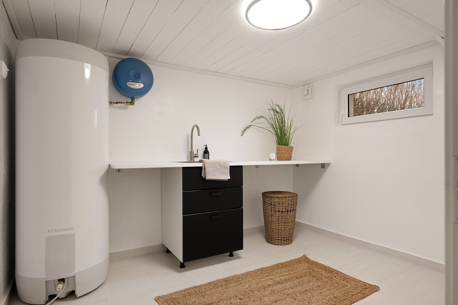 Vaskerommet som er pusset opp i 2026, ligger i tilknytning til badet og har fliser på gulv og varmekabler Galleribilde