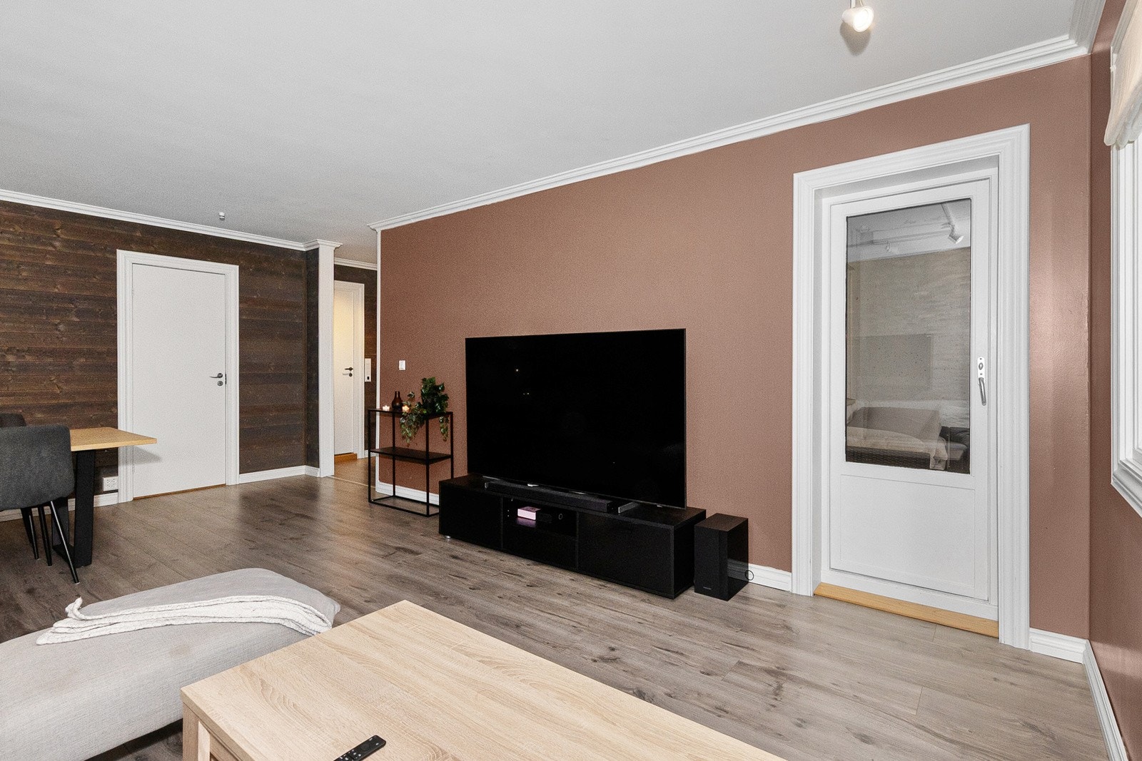 Stue med oppkobling av tråløst internett og TV plassert på vegg ved verandadør. Galleribilde