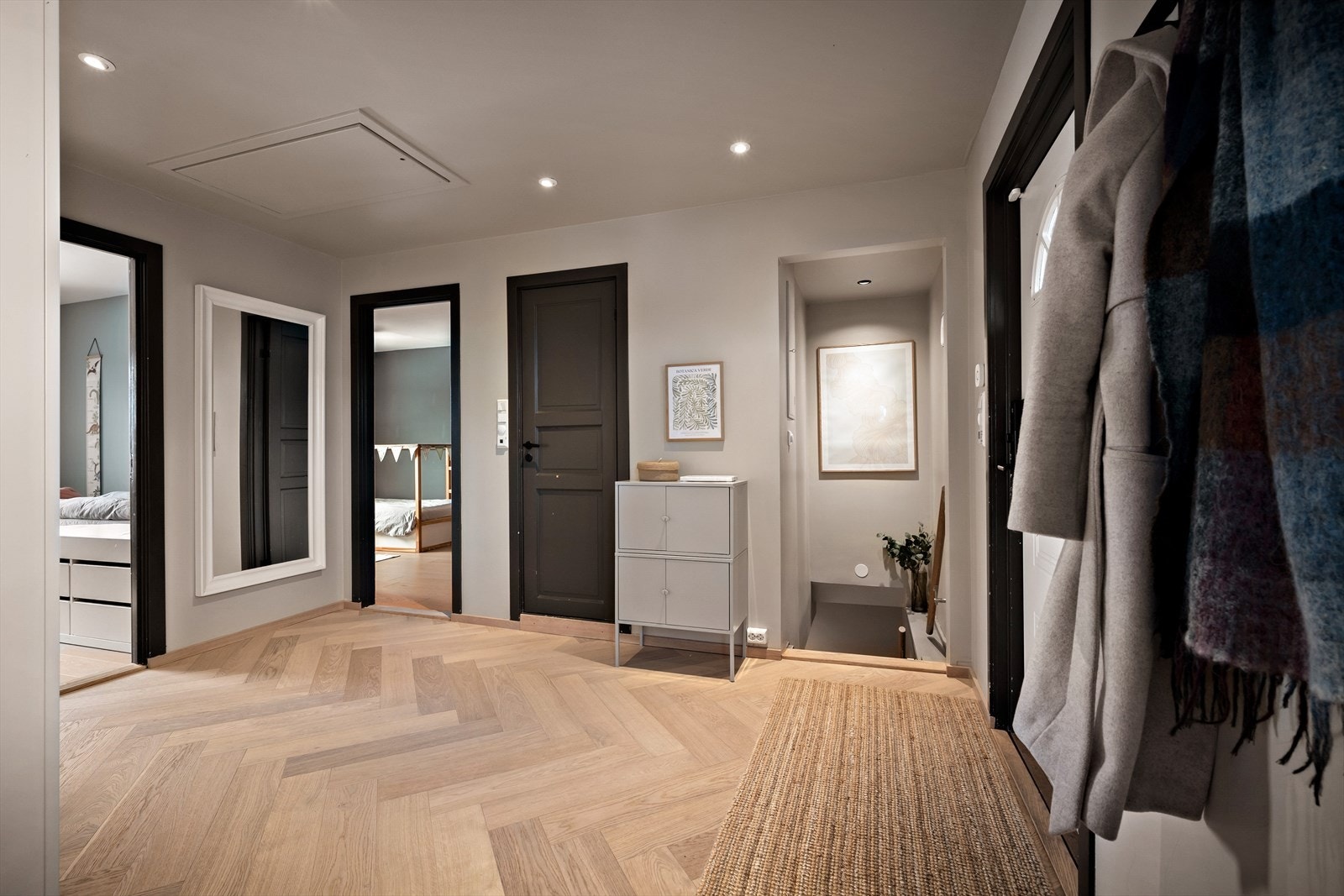 Hallen har fiskebeinsparkett, lysmalte overflater og god belysning fra downlights. Det er adkomst til bad, stue/kjøkken, 2 soverom og ned til u.etg. I taket det luke opp til loftet. Galleribilde