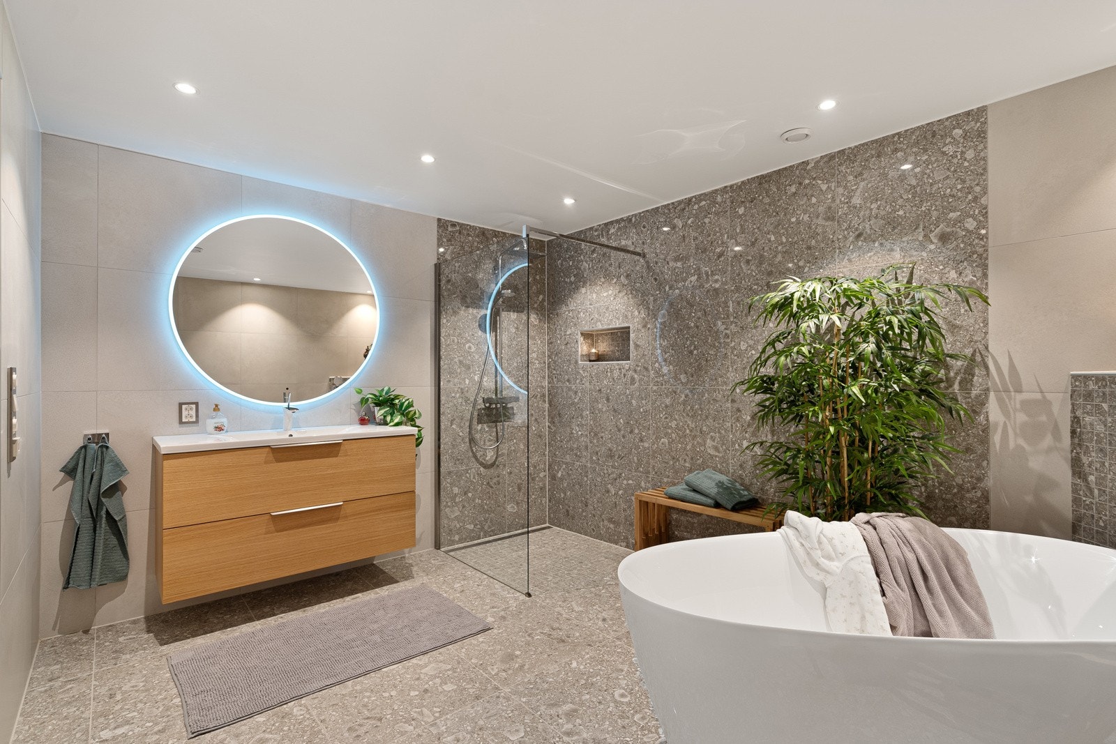 Moderne baderomsinnredning med tilhørende, smekkert speil med belysning. Galleribilde