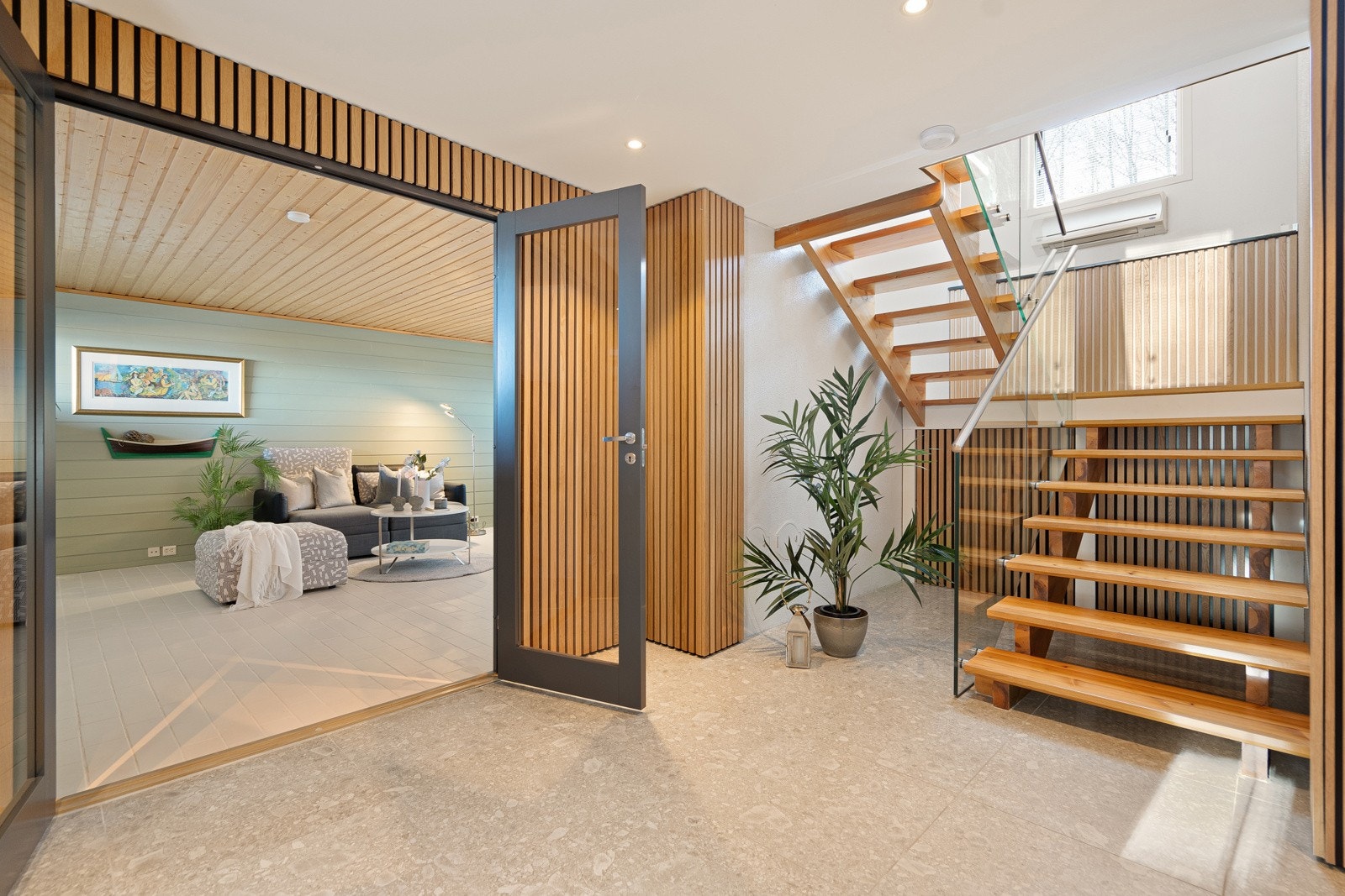 Trappen som fører opp til hovedetasjen og inngang til stuen i underetasjen. God oppbevaringsplass under trapperepos Galleribilde