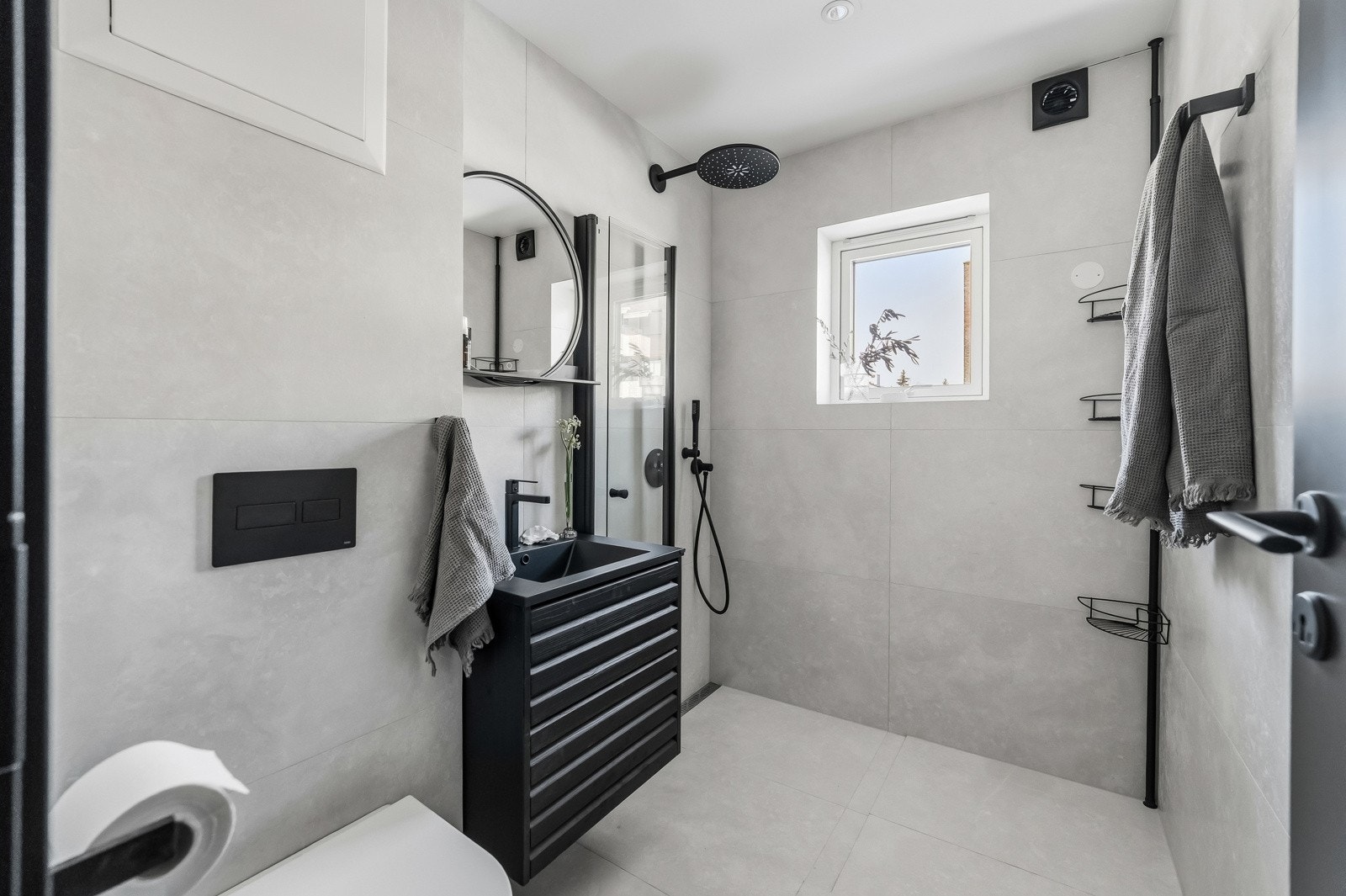 Moderne baderom i samme etasje med flislagte overflater og stilren innredning. Badet er utstyrt med dusj, vegghengt toalett, servantinnredning og elektrisk gulvvarme for økt komfort. Galleribilde