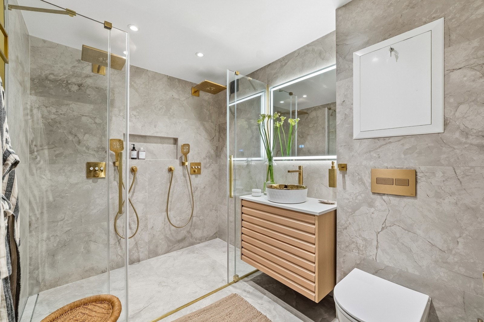 Delikat og påkostet baderom med eksklusive flislagte overflater og gjennomført materialvalg. Badet er utstyrt med dobbel dusjløsning med to takdusjer, dusjvegger i glass, vegghengt toalett og stilren servantinnredning. Galleribilde