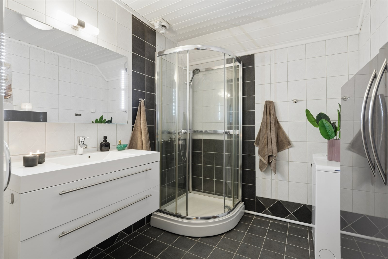 Badet i gjesteleilighet/ungdomsavdeling i andre etasje er utstyrt med dusjhjørne og servantinnredning og med god skapplass og opplegg for vaskemaskin Galleribilde