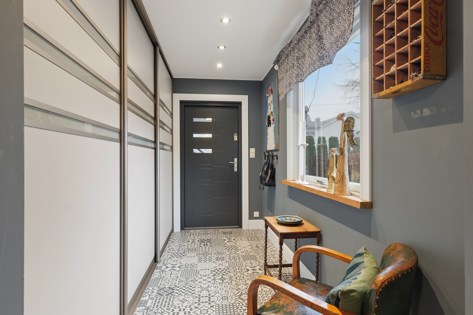 Entréen i hovedenheten ønsker velkommen med karakteristiske gulvfliser og en romslig skyvedørsgarderobe. Galleribilde