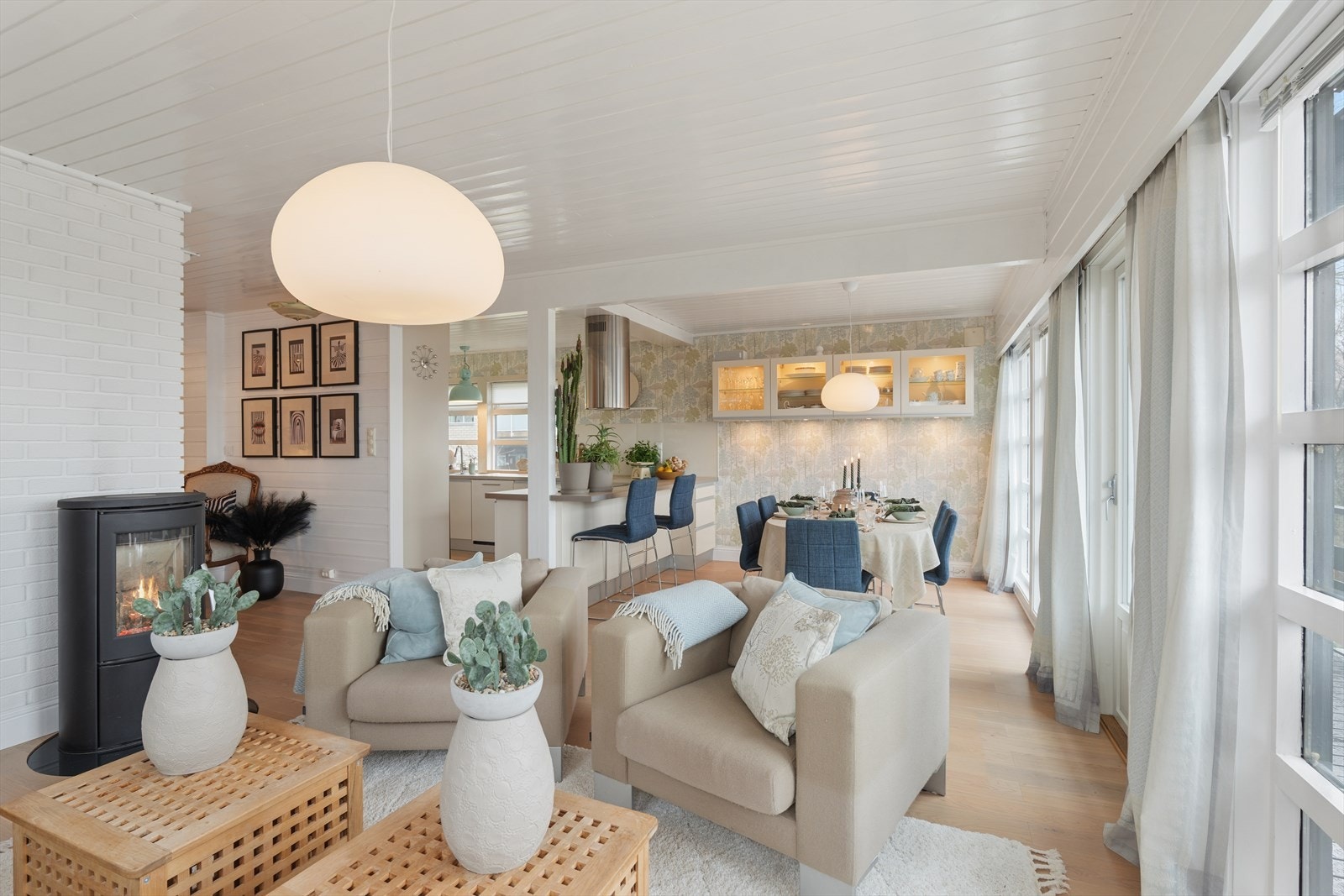 Vedovnen skaper en lun atmosfære i stuen. Boligen har også en peisinnsats med nytt stålrør fra 2025. Galleribilde