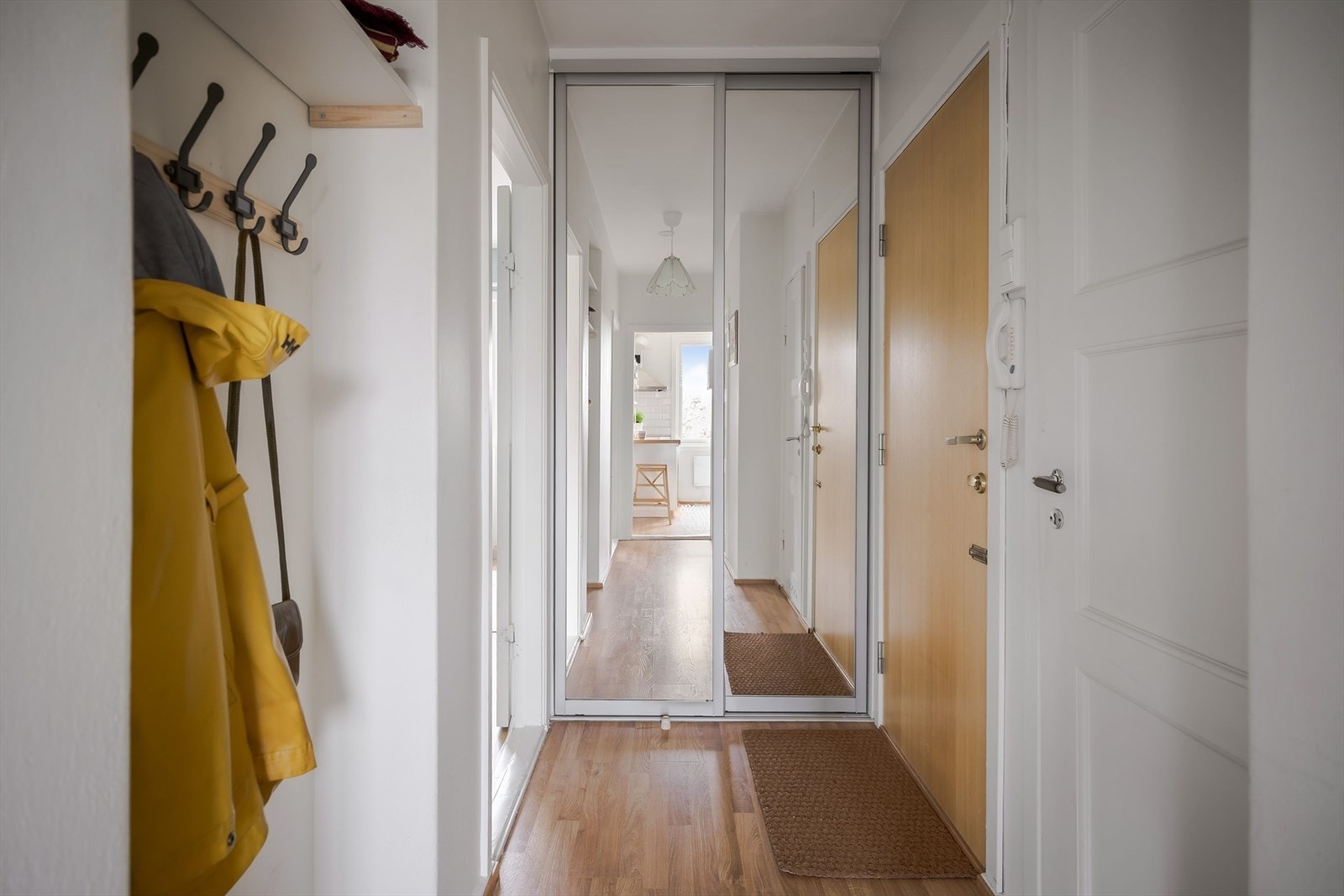 Entréen er praktisk med et areal på ca. 5,2 kvm. Den er innredet med skyvedørsgarderobe med speilfronter og knaggrekke i nisje. Galleribilde