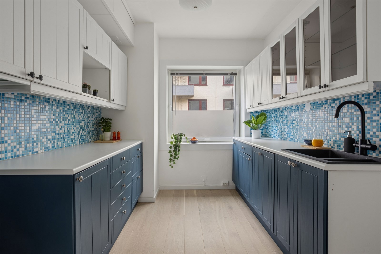 Kjøkkenet er praktisk innredet med profilerte fronter og rikelig med benke- og skapplass på begge sider. Galleribilde