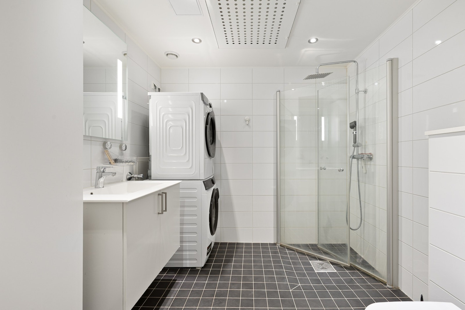 Delikat flislagt bad med praktisk og plassbesparende innredning. Galleribilde