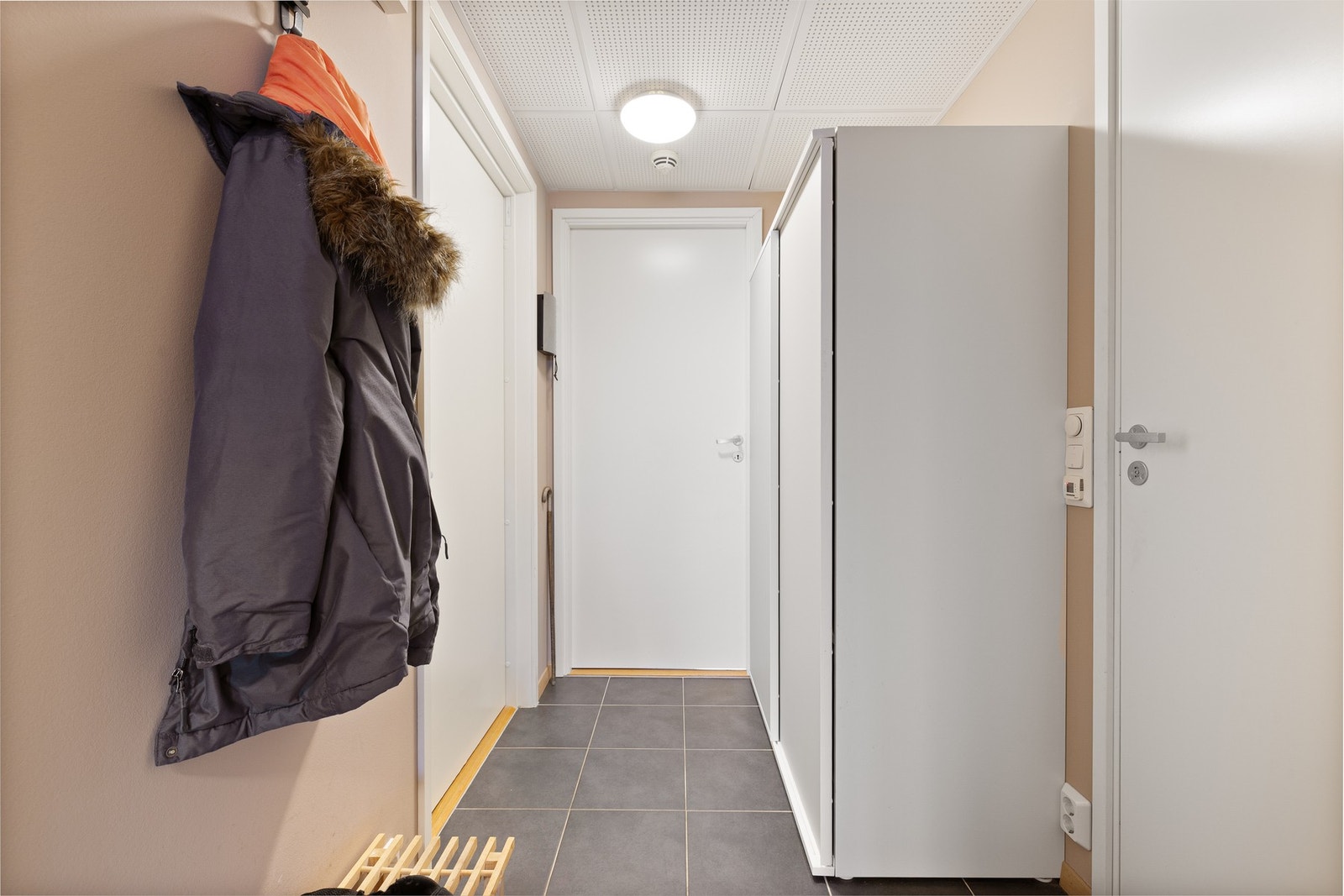 Flislagt gang/entré med varmekabler i gulv og garderobe for ytterklær. Galleribilde