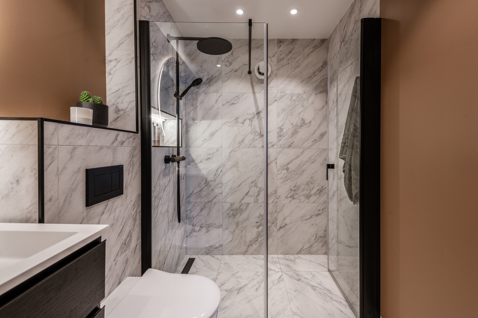 Badet har stor dusj med glassvegg og mekanisk avtrekk Galleribilde