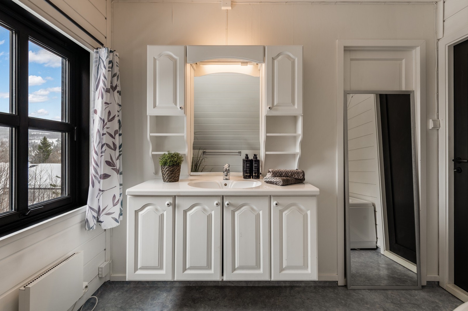 Badet er innredet med badekar, toalett og baderomsinnredning med vask Galleribilde