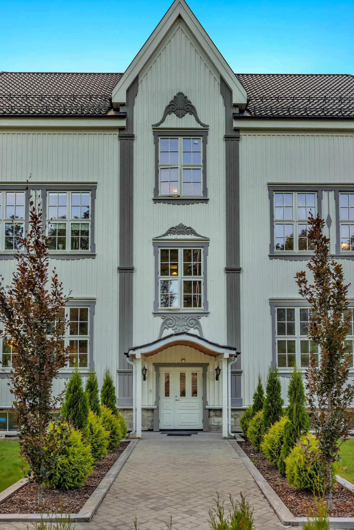 Felles inngangsparti er nydelig med beplantning på hver side og elegant overbygg over ytterdøren. Galleribilde