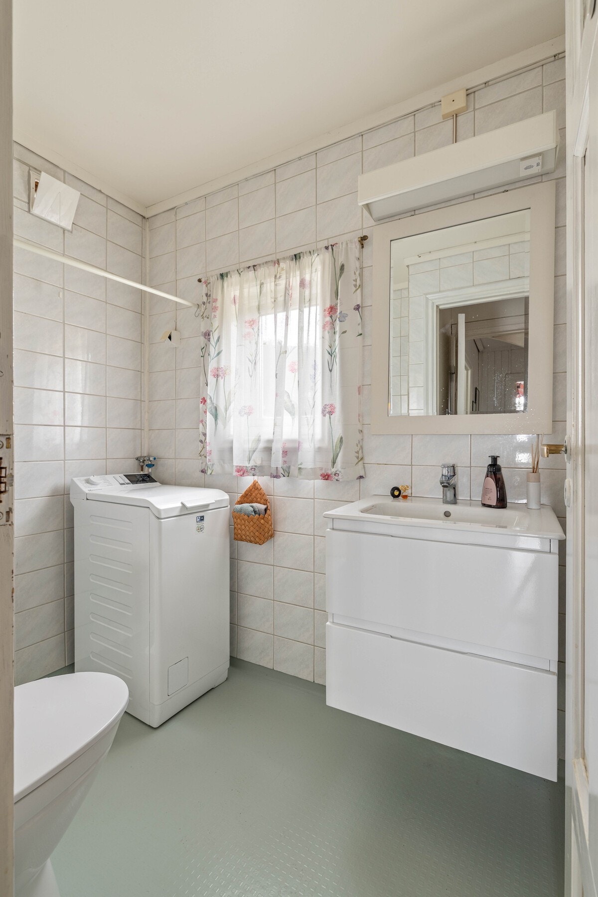 Bad med belegg på gulv, fliser på vegger, malte plater i himling, naturlig ventilasjon, servantskap, dusj, toalett på gulv. Galleribilde