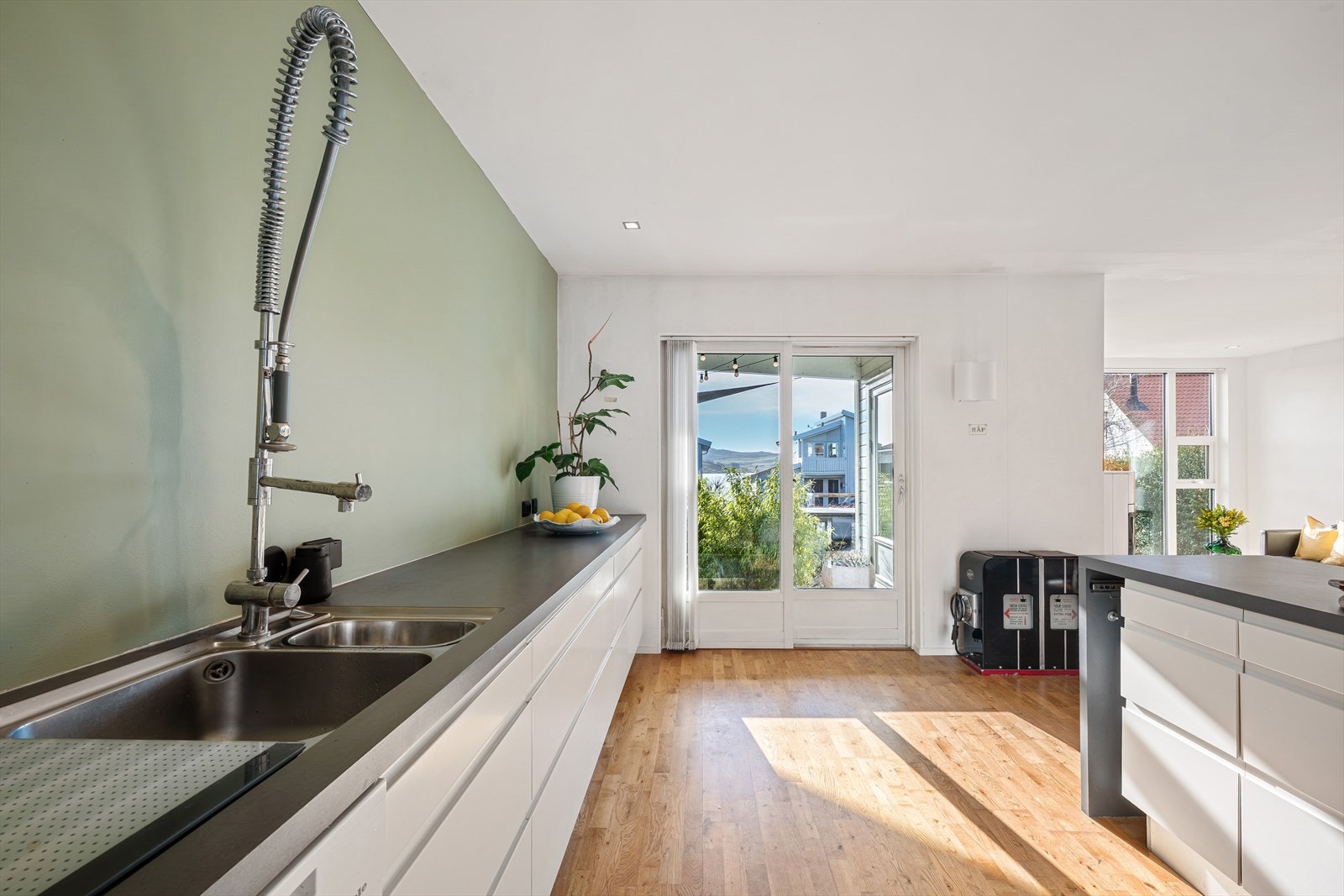 Fra kjøkkenet har du direkte utgang til terrasse og videre ned til hagen på baksiden av boligen. Galleribilde