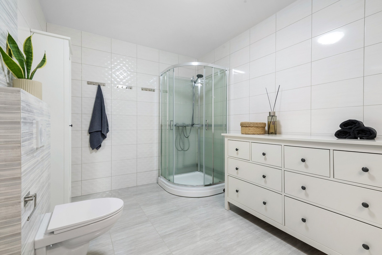 Bad i 1. etasje. Meget romslig bad med godt med skapplass og stor dusj. Rommet har vannbåren varme og fliser som overflate. Galleribilde